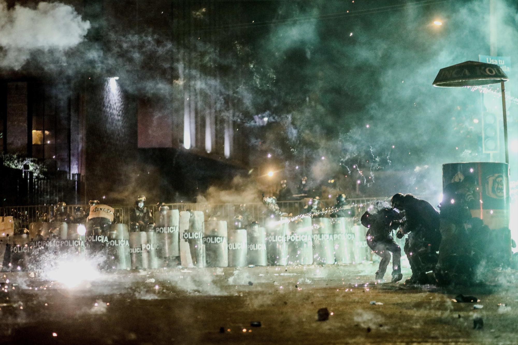 Policías disparan bombas lacrimógenas contra los manifestantes hoy jueves en la Plaza San Martin en Lima. (EFE/Aldair Mejía)