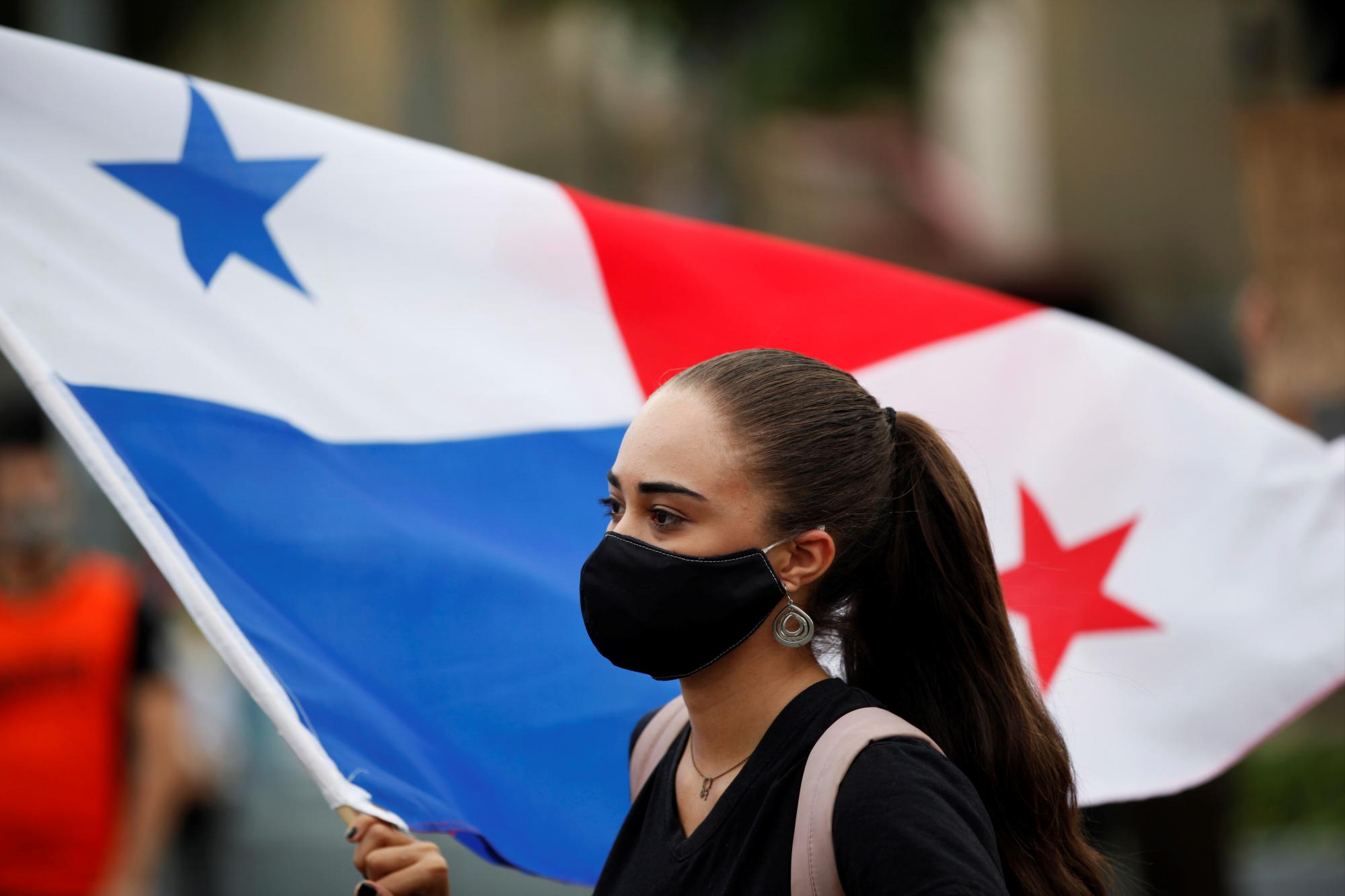 Una mujer ondean una bandera panameña mientras participa en una protesta este miércoles, en las afueras de la Asamblea Nacional de Panamá (EFE/ Bienvenido Velasco)