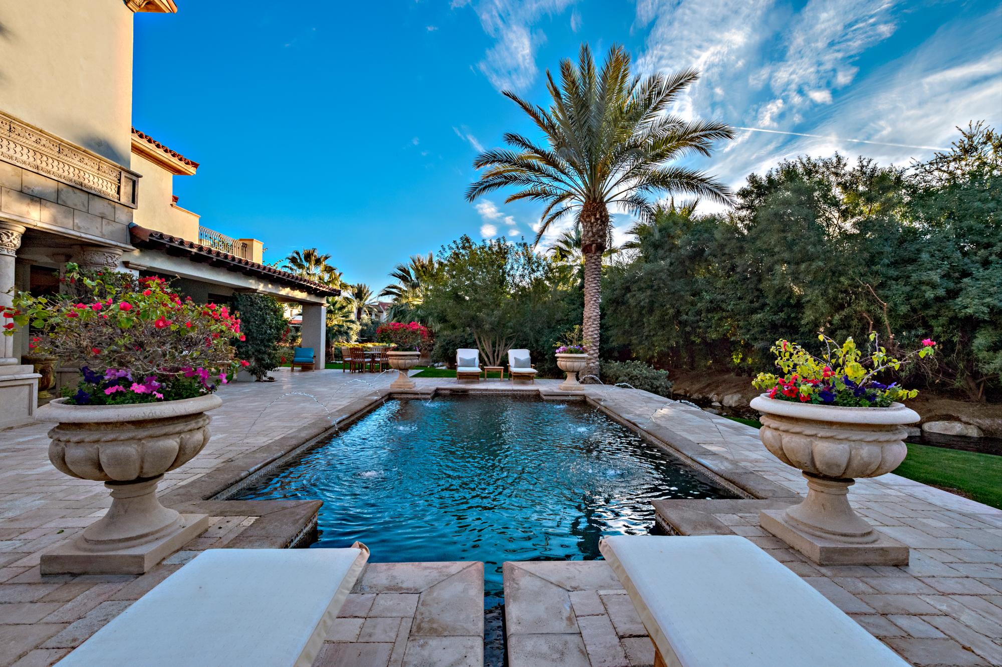 Afuera se puede apreciar una hermosa piscina y spa, exuberantes plantaciones, fuentes de agua y un arroyo que atraviesa la propiedad.