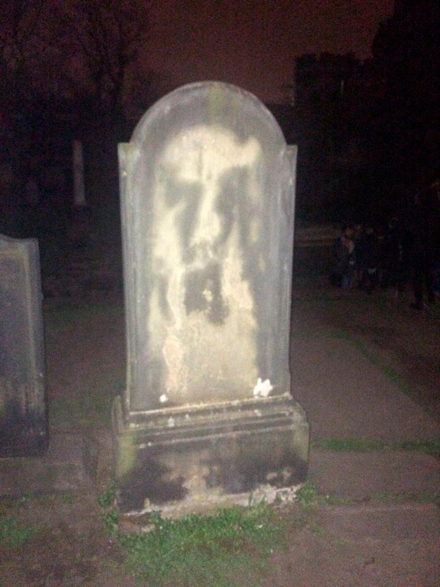 Tumba del pintor David Allan, en el cementerio de Old Calton en Edimburgo. En su l·pida se puede observar una gran mancha que se asemeja a un rostro con la boca muy abierta.