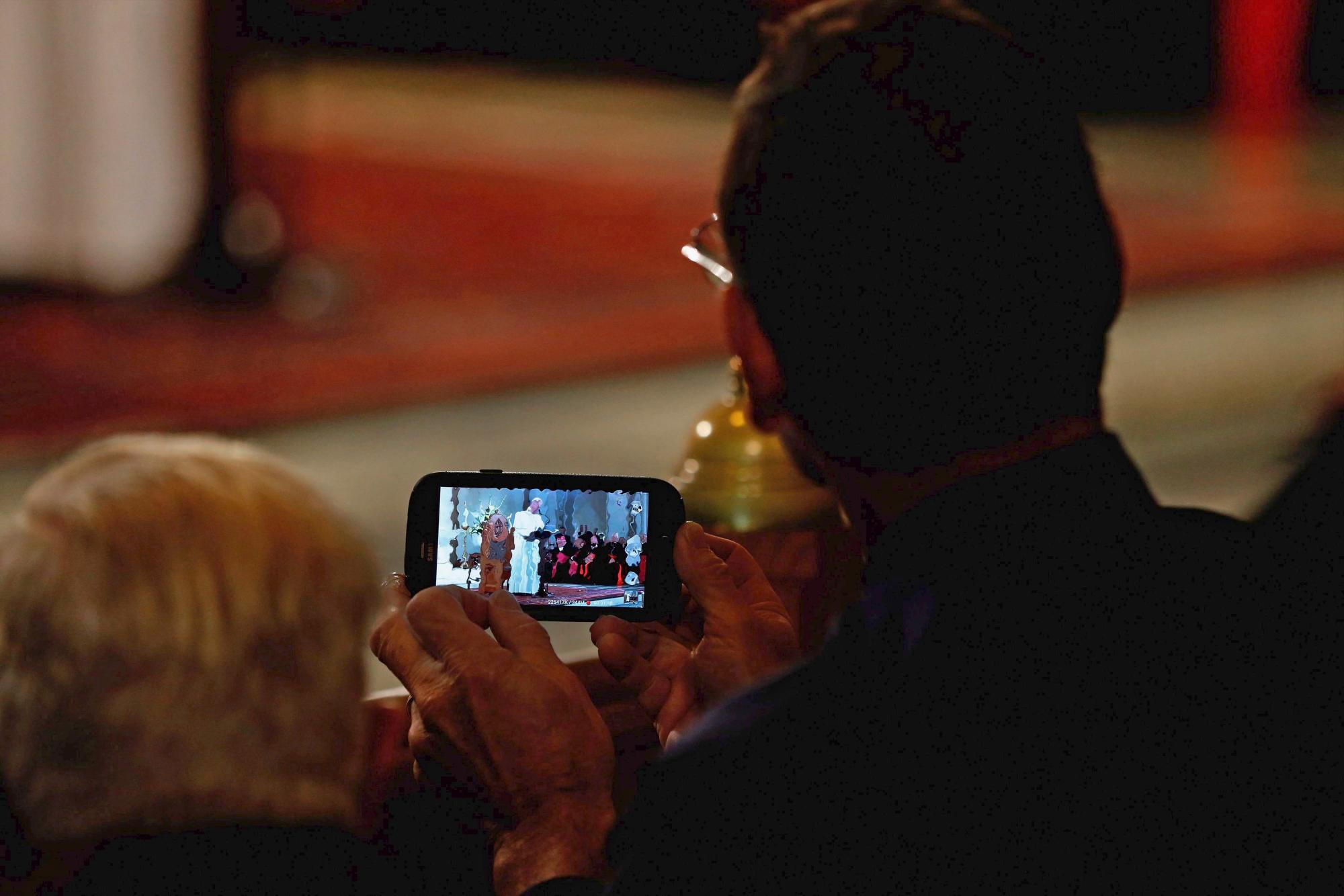 Un hombre usa un teléfono inteligente para grabar el video del Papa Francisco a los reunidos en la Iglesia Católica de San Patricio en Washington DC, EE. UU., El 24 de septiembre de 2015. El Papa Francisco está realizando un viaje de cinco días a los Estados Unidos, que incluye paradas en Washington DC. Nueva York y Filadelfia, después de una estancia de tres días en Cuba.