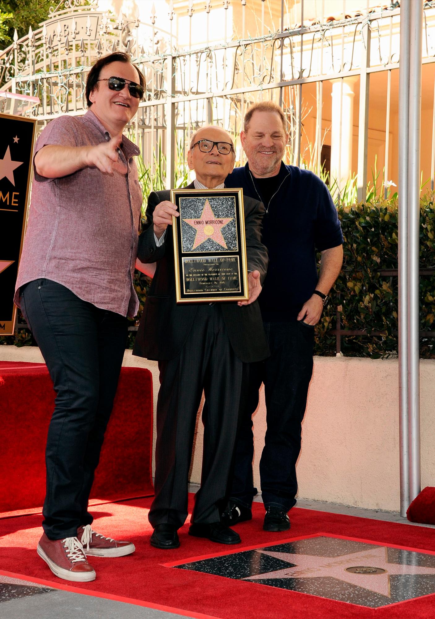 El director estadounidense Quentin Tarantino (L) y el productor estadounidense Harvey Weinstein (R) posan con el compositor italiano Ennio Morricone (C) durante una ceremonia en Hollywood, California, EE. UU., el 26 de febrero de 2016 Morricone recibió la estrella 2.574 en el Paseo de la Fama en la categoría de Actuación en vivo/teatro.