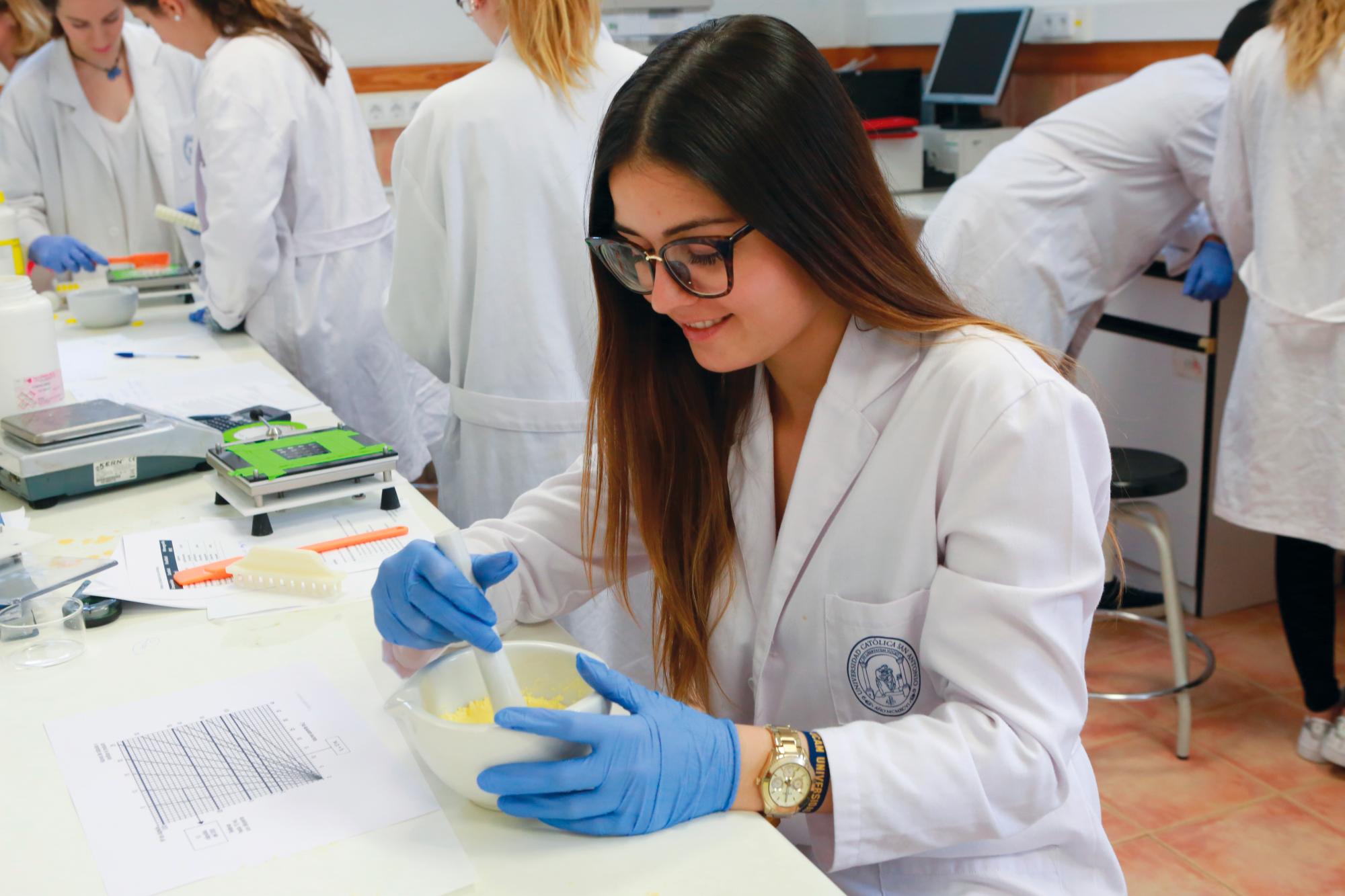 Una estudiante realiza prácticas en el laboratorio de la UCAM, la universidad española que recibe cada año más de 500 alumnos latinoamericanos. 