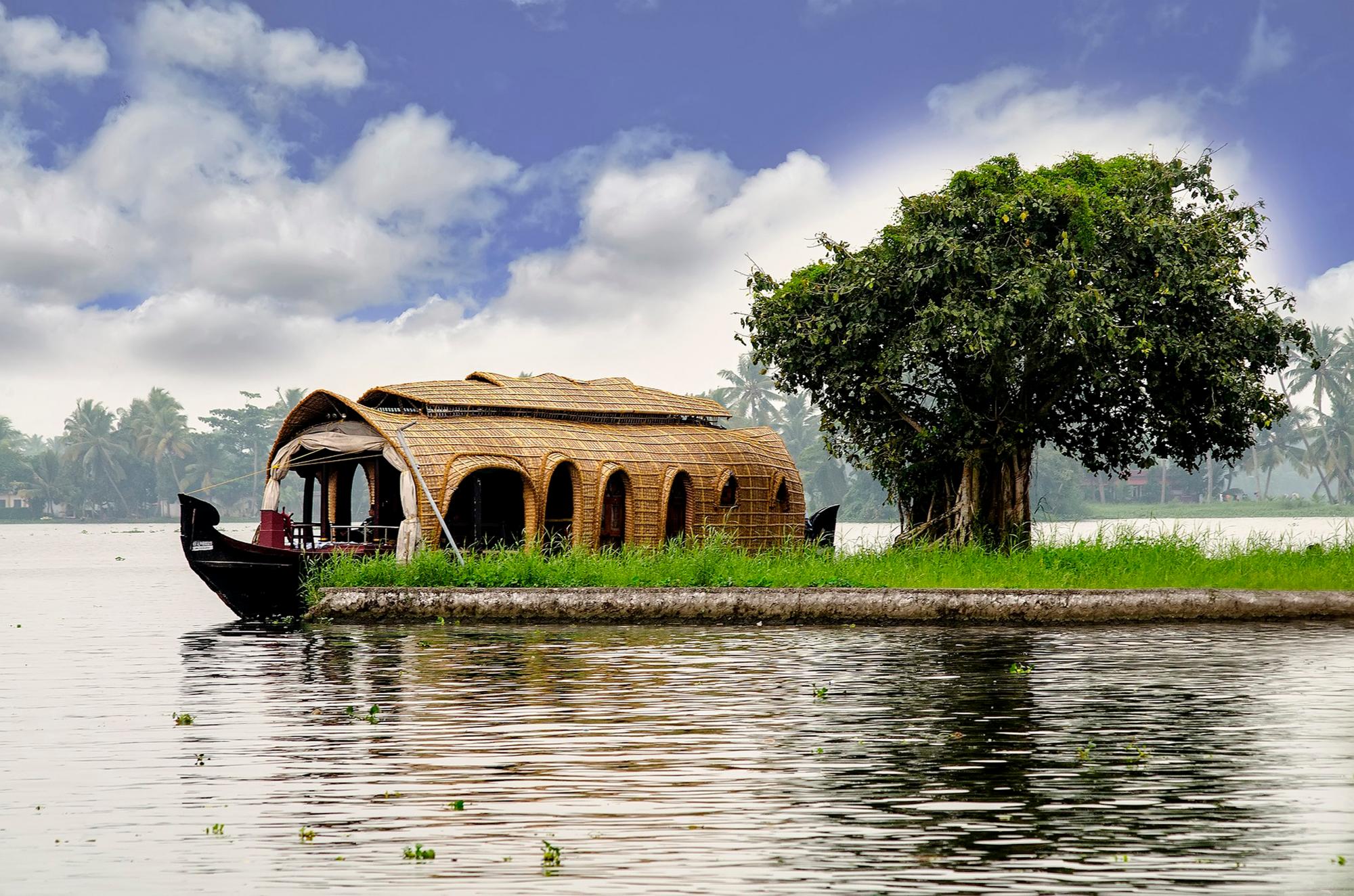 Una bella imagen de una casa flotante en Kerala, India con un paisaje muy sugerente alrededor.