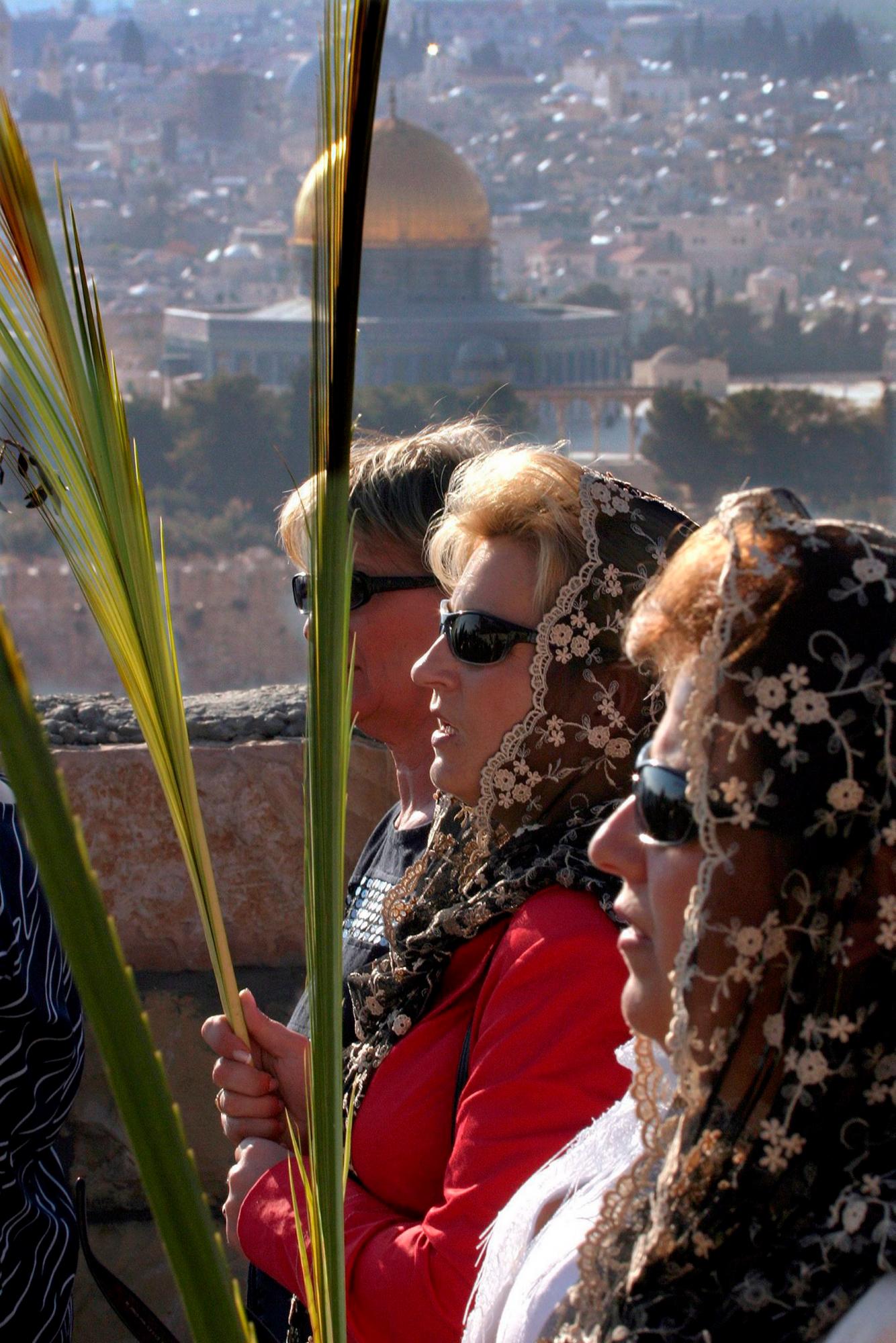 Tres mujeres de Cracovia, en Polonia, participan en una procesión en el Monte de los Olivos en Jerusalén, recorriendo el camino que hizo Jesucristo para entrar en la ciudad, durante el domingo de ramos, que da comienzo a la Semana Santa.