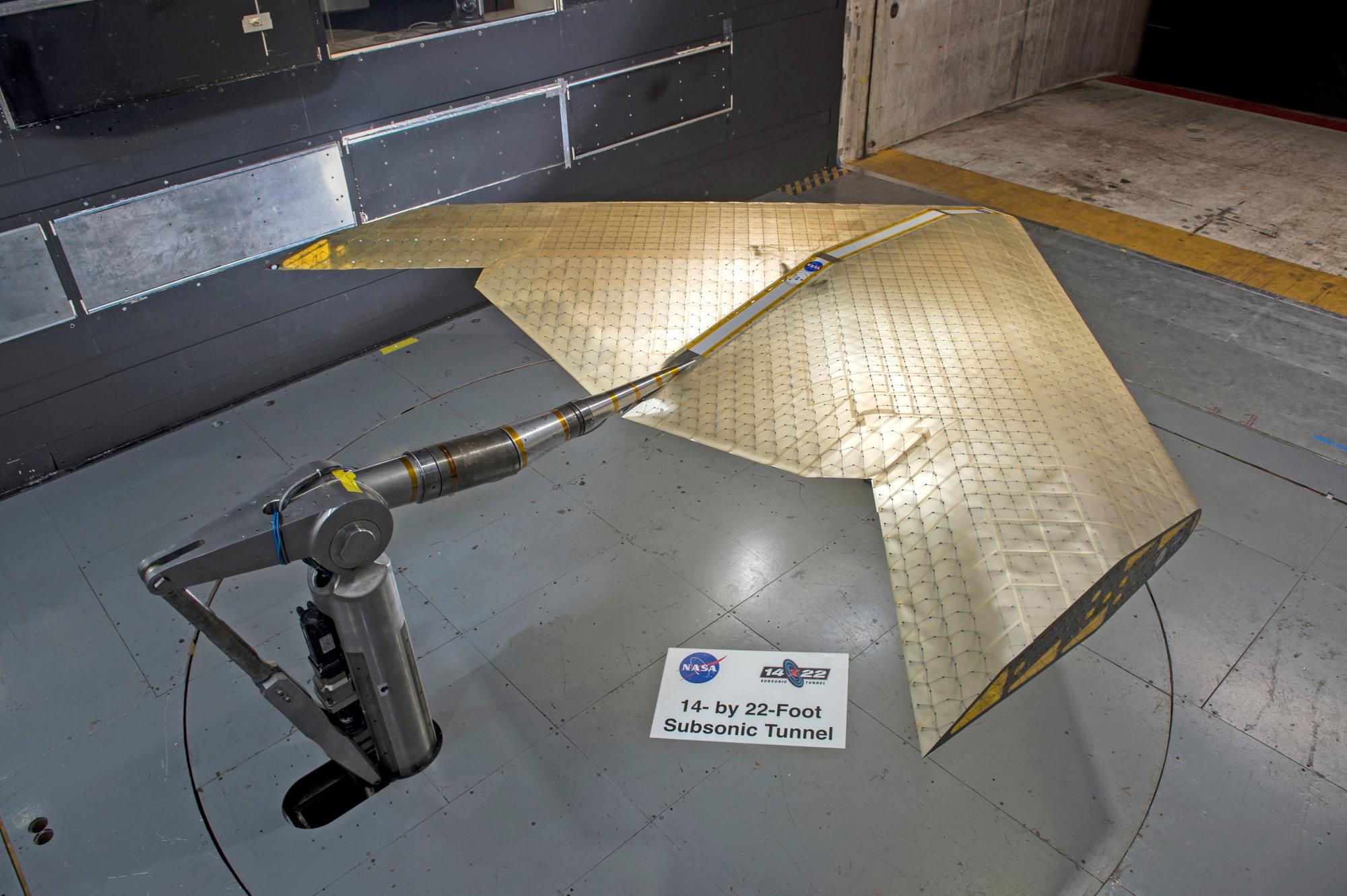 El ensamblaje del ala se ve en construcción, ensamblado a partir de cientos de subunidades idénticas. El ala fue probada en un túnel de viento de la NASA.