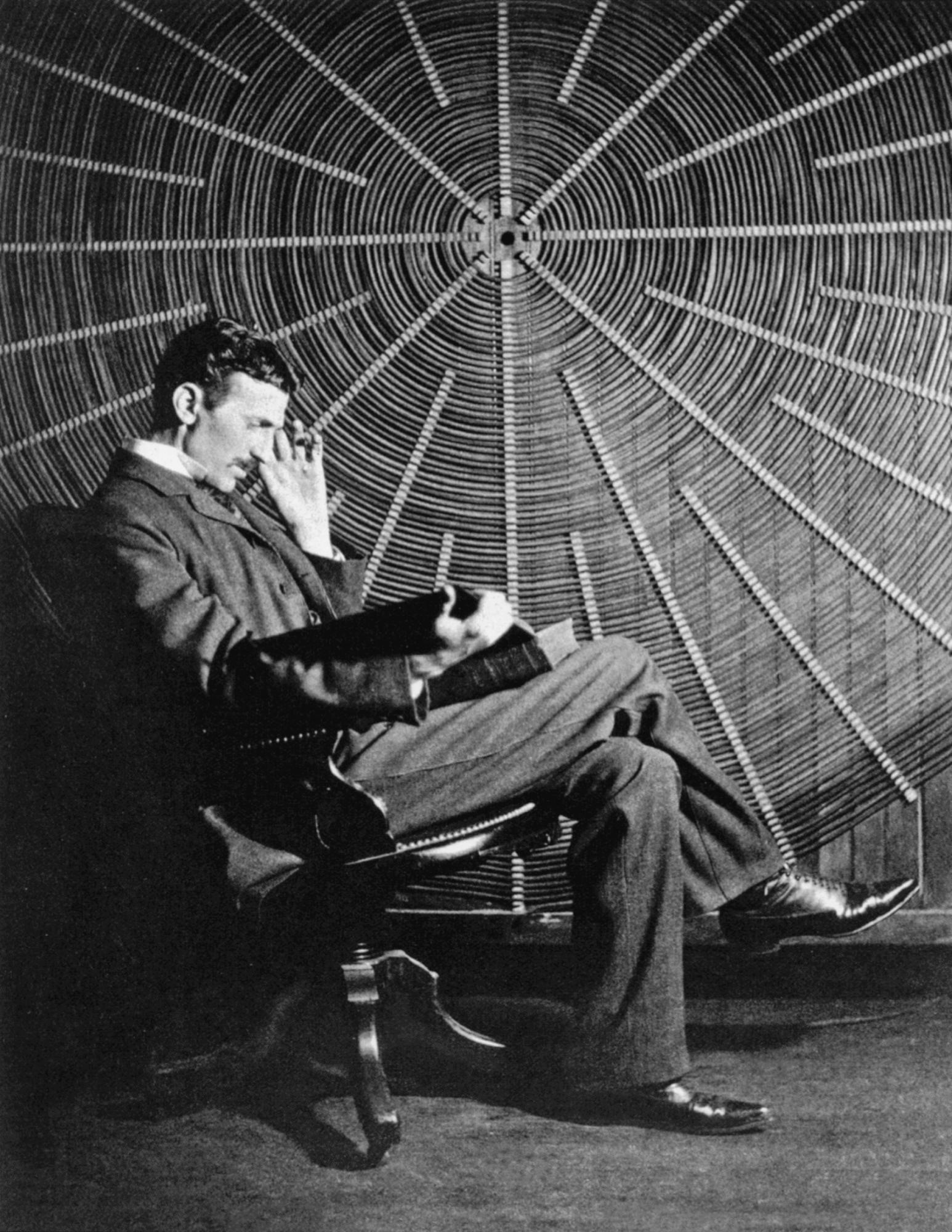 Tesla sentado ante uno de sus inventos a principios de siglo. 