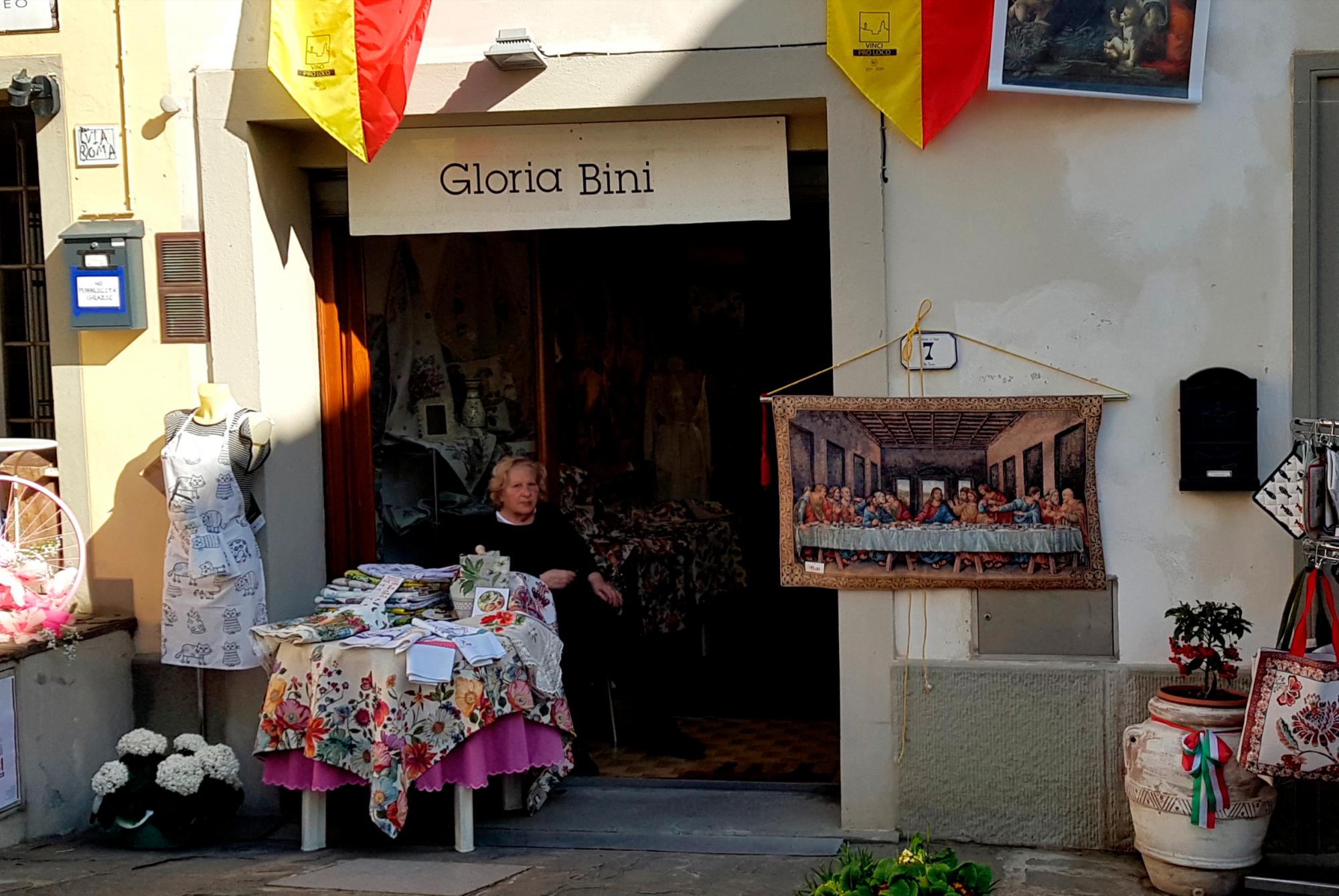 Una mujer cose a las puertas de su negocio de souvenirs en el municipio natal de Leonardo Da Vinci. 