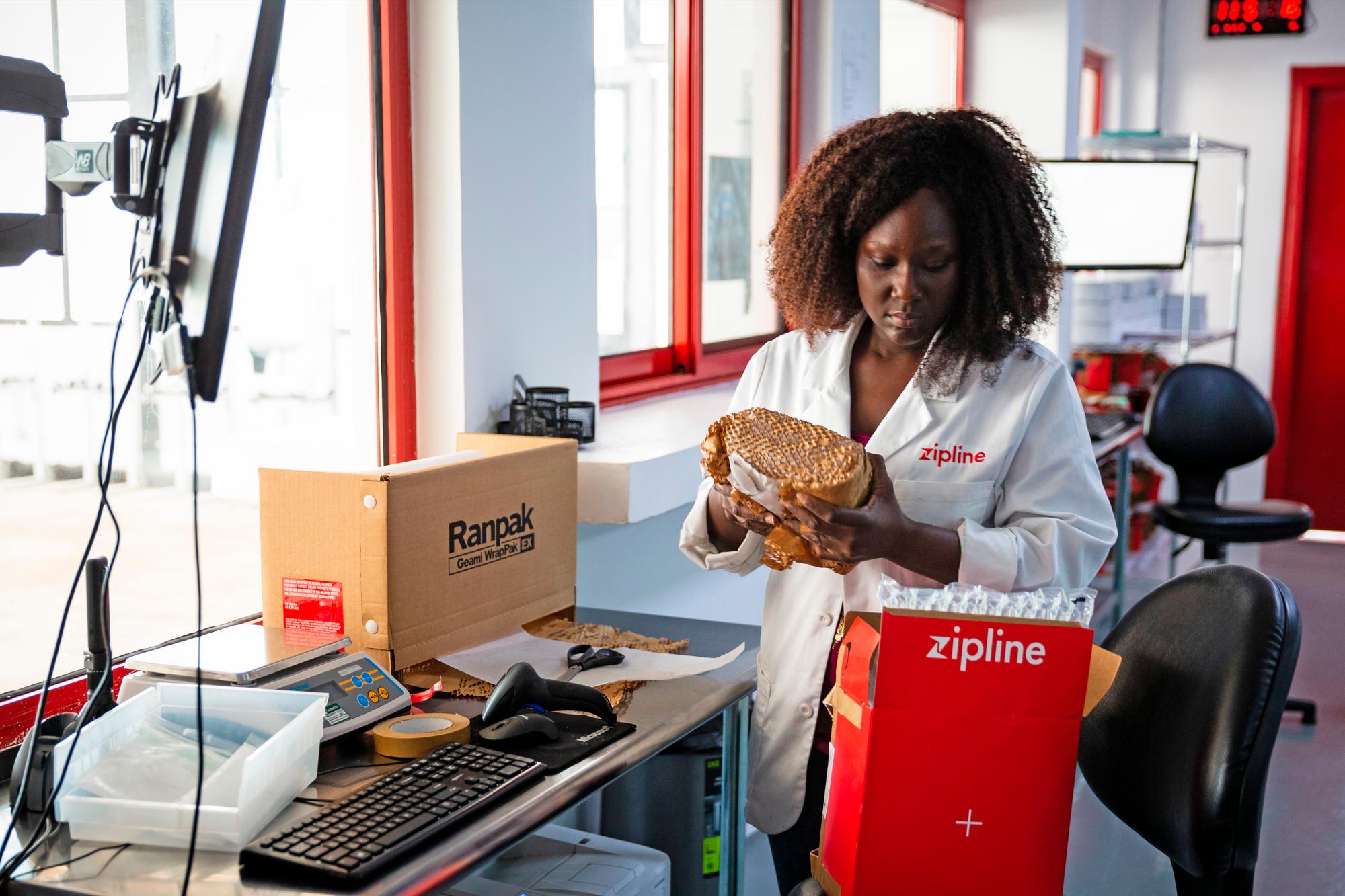Una operaria de la empresa estadounidense Zipline coloca medicinas en un paquete para su posterior entrega a través de un dron en Ghana.