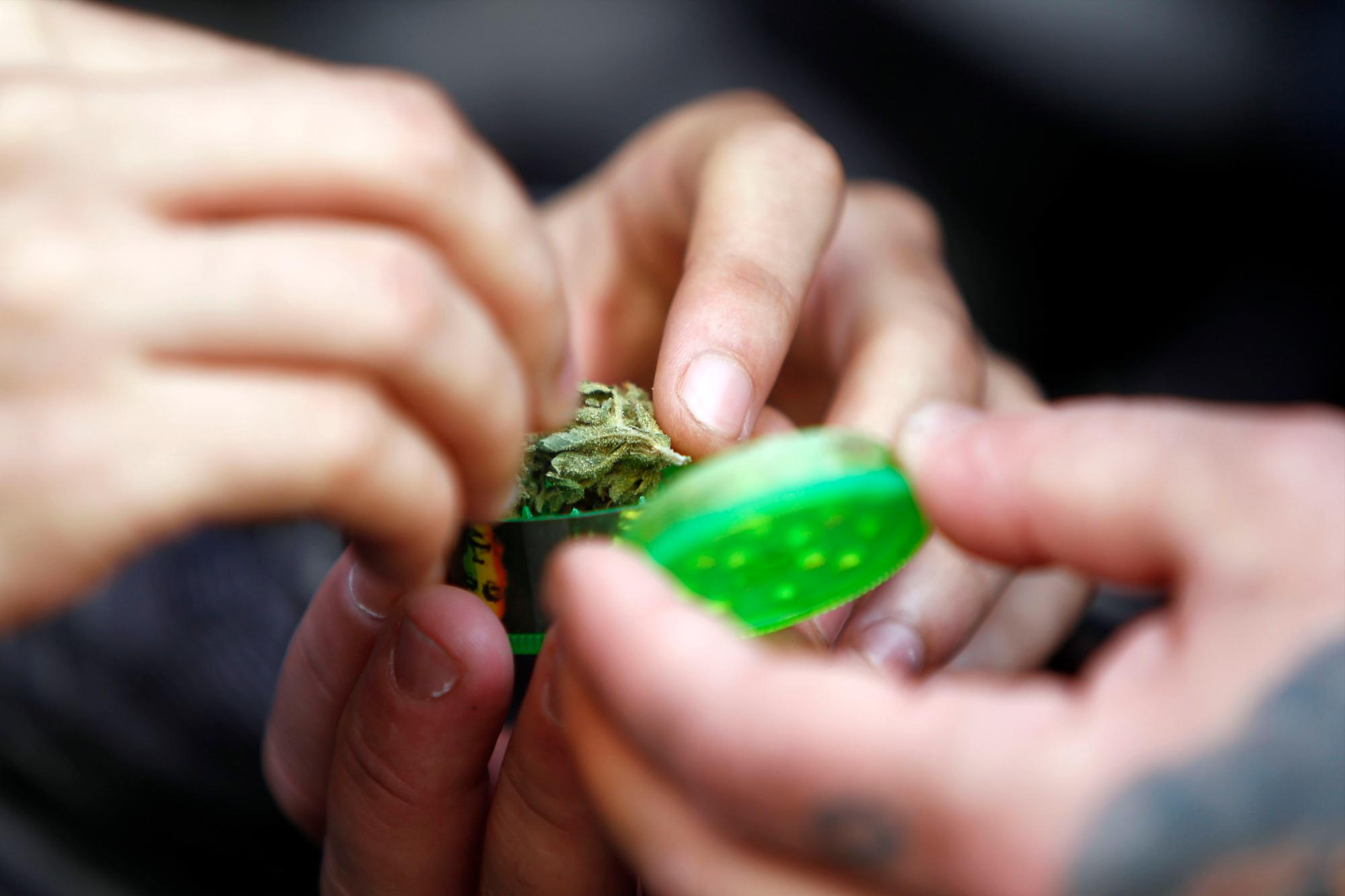 Jóvenes uruguayos preparan un cigarro de marihuana junto a una farmacia de Montevideo (Uruguay). 