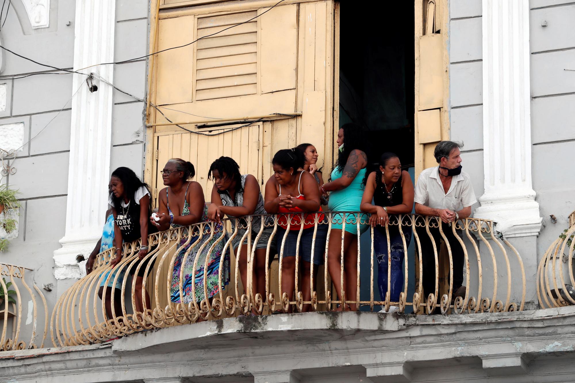 LA HABANA (CUBA), 11/07/2021.- Varias personas observan desde su azotea las manifestaciones hoy, en La Habana (Cuba). Cientos de cubanos salieron este domingo a las calles de La Habana al grito de libertad en manifestaciones pacíficas, que fueron interceptadas por las fuerzas de seguridad y brigadas de partidarios del Gobierno, produciéndose enfrentamientos violentos y arrestos. EFE/Ernesto Mastrascusa