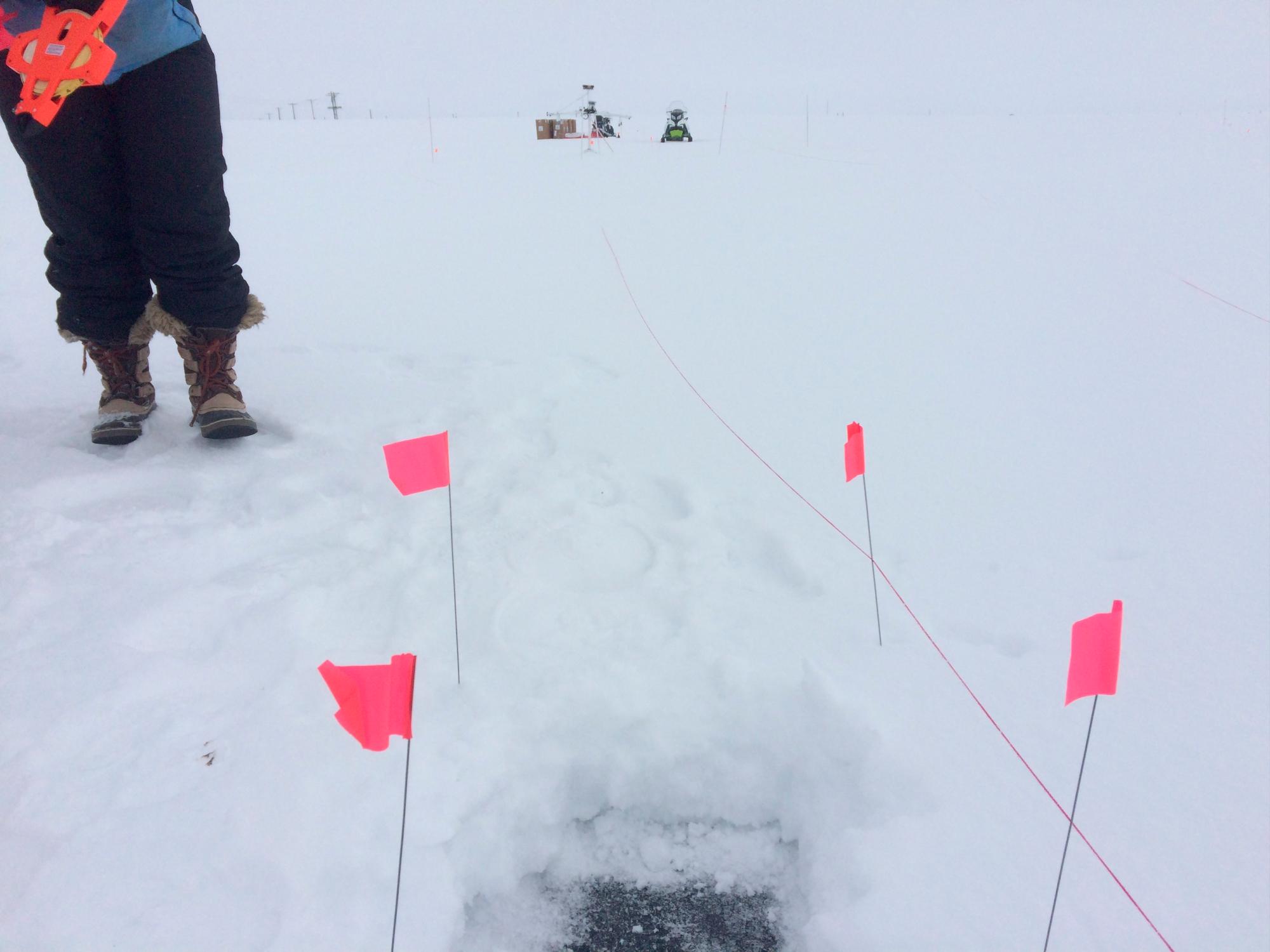 Colocación de marcadores para identificar un área de hielo donde se esparcirá una capa de material reflectante. 