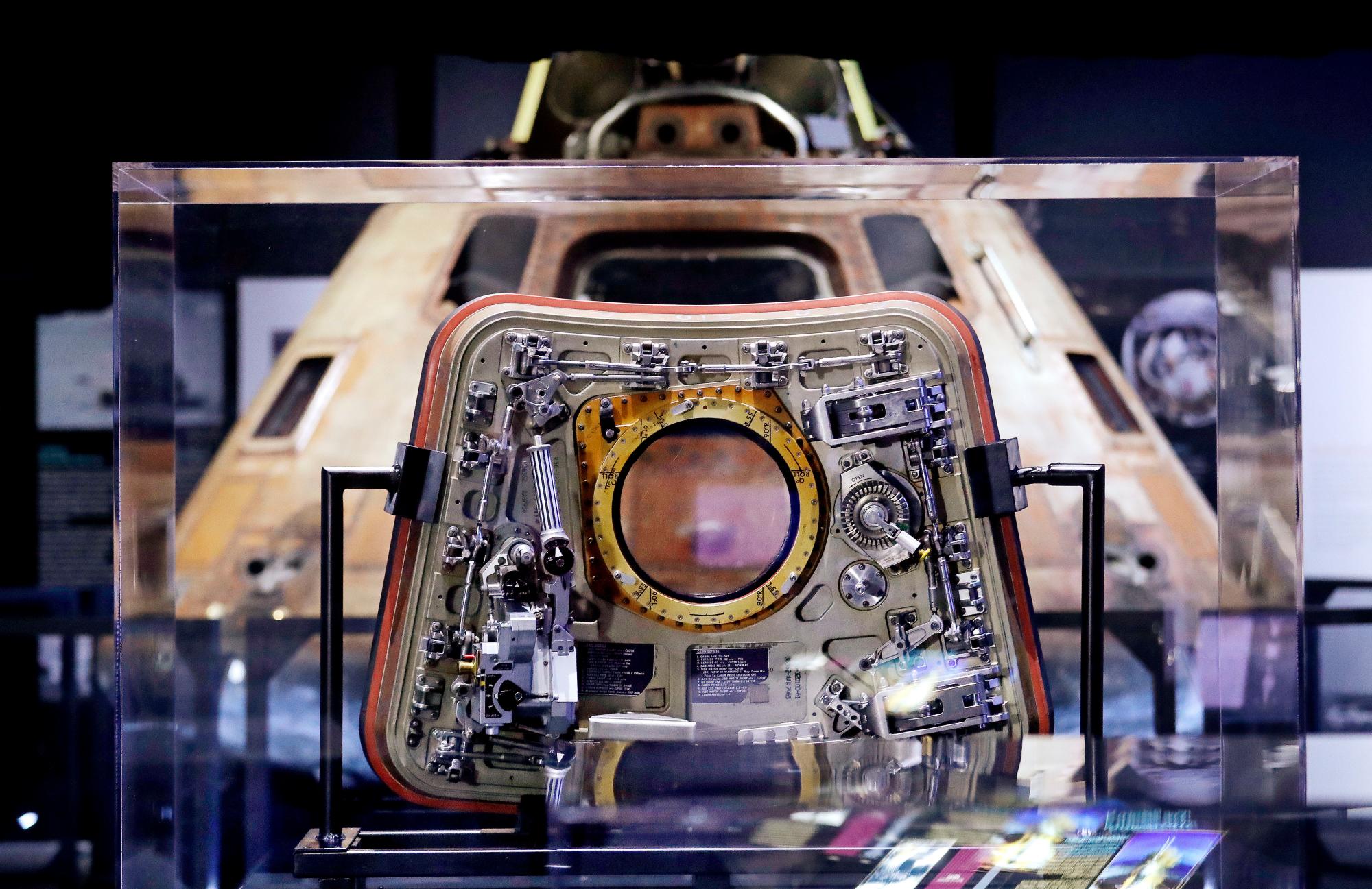 La escotilla del módulo de comando de la NASA Apolo 11, Columbia, se muestra detrás del vidrio, delante del módulo que está detrás, la pieza central de Destination Moon: La exhibición de la misión Apolo 11 en el Museo de Vuelo en Seattle.