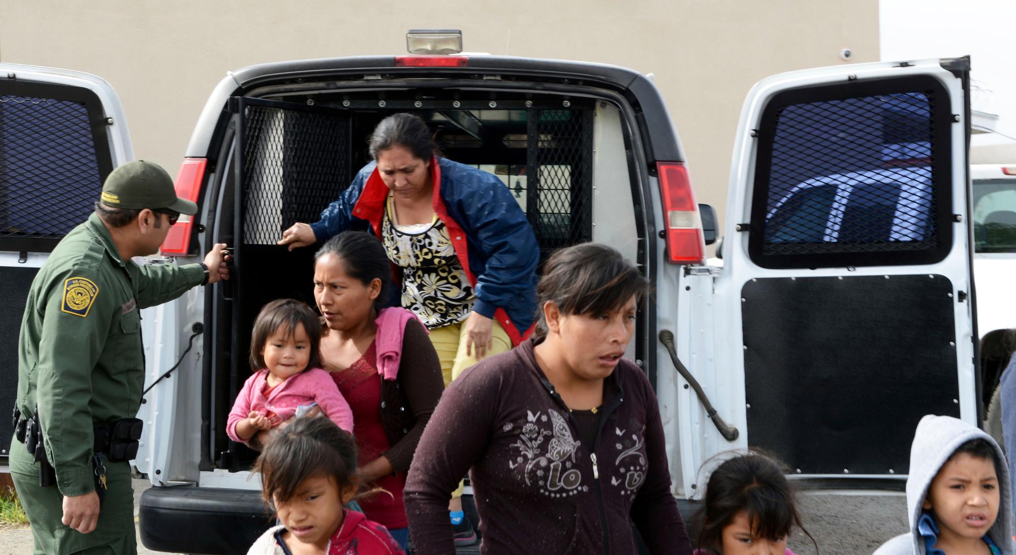 Un agente de la Patrulla Fronteriza de los EEUU ayuda a los migrantes a salir de una camioneta en la Misión de Rescate del Evangelio en Las Cruces, Nuevo Mexico.