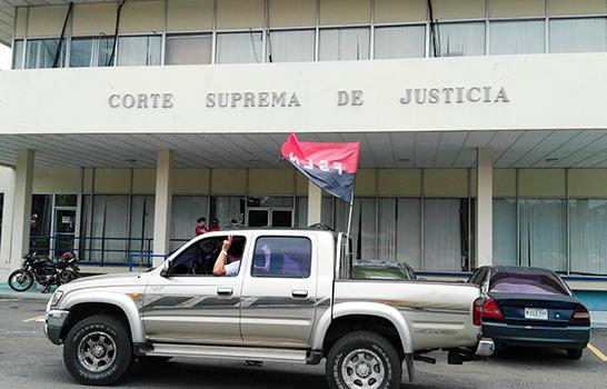 Un militante sandinista pasa frente a las instalaciones de la Corte Suprema de Justicia en Managua.  