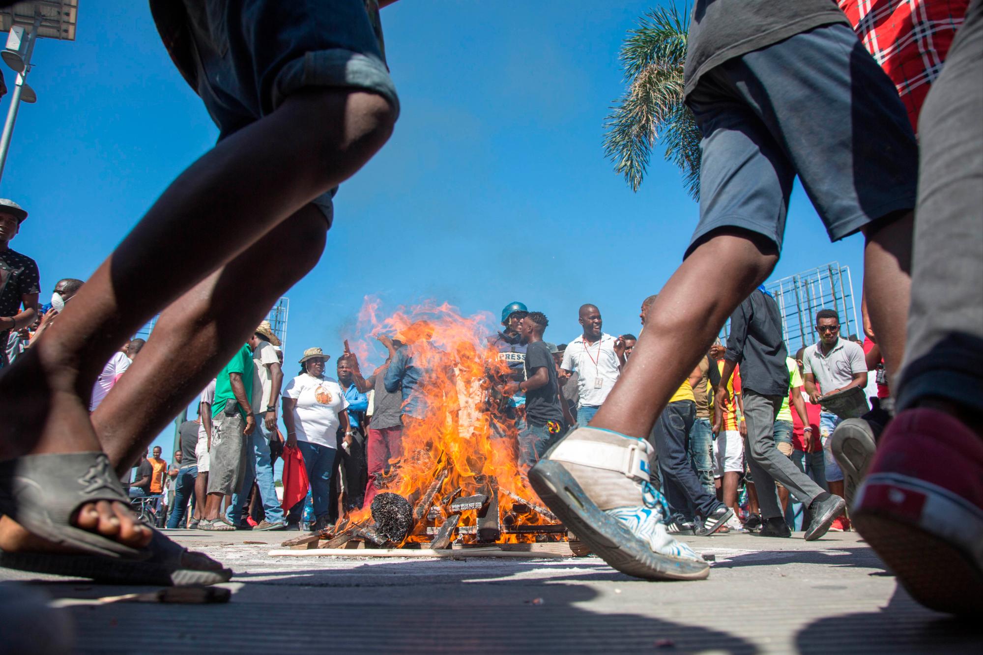 Hombres bailan alrededor de una barricada durante una protesta, en Puerto Príncipe (Haití) hoy, domingo 18 de noviembre de 2018. Miles de haitianos salieron hoy a las calles para participar en una nueva protesta nacional contra la corrupción y la impunidad, que ha dejado al menos dos muertos y varios heridos.