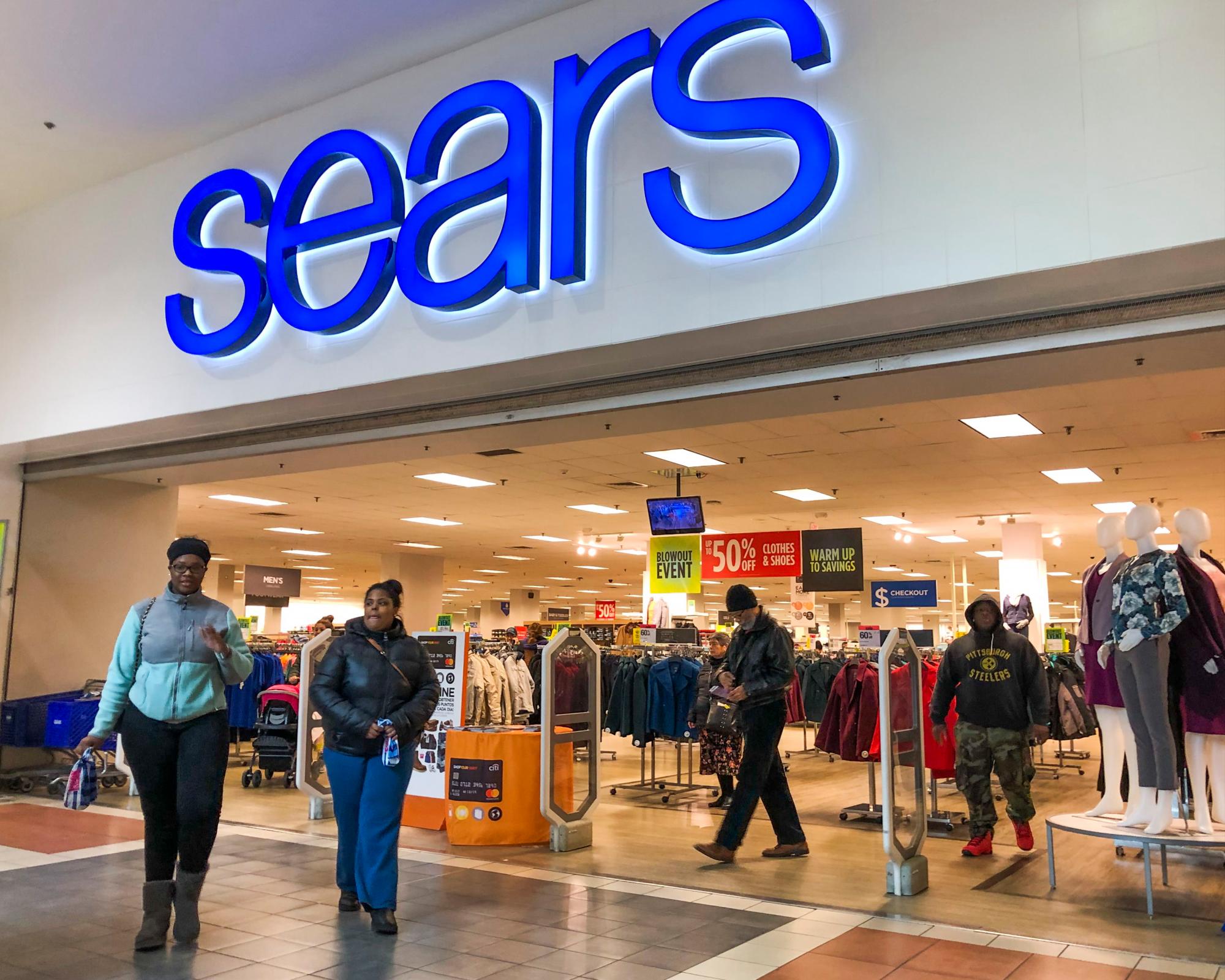 Clientes salen de la tienda por departamentos Sears en Riverside, Illinois, USA.