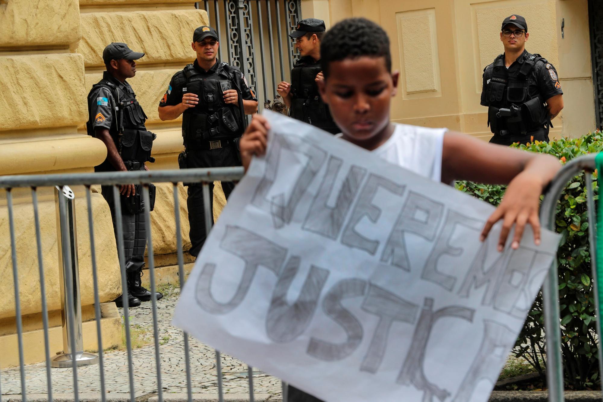 Un adolescente sostiene un cartel en una manifestación para exigir al gobierno del estado de Río de Janeiro el pago de una indemnización a favor de la familia de la niña María Eduarda, de apenas 13 años, que murió por una bala perdida el 30 de marzo de 2017, en una escuela pública durante una acción de la Policía Militar.