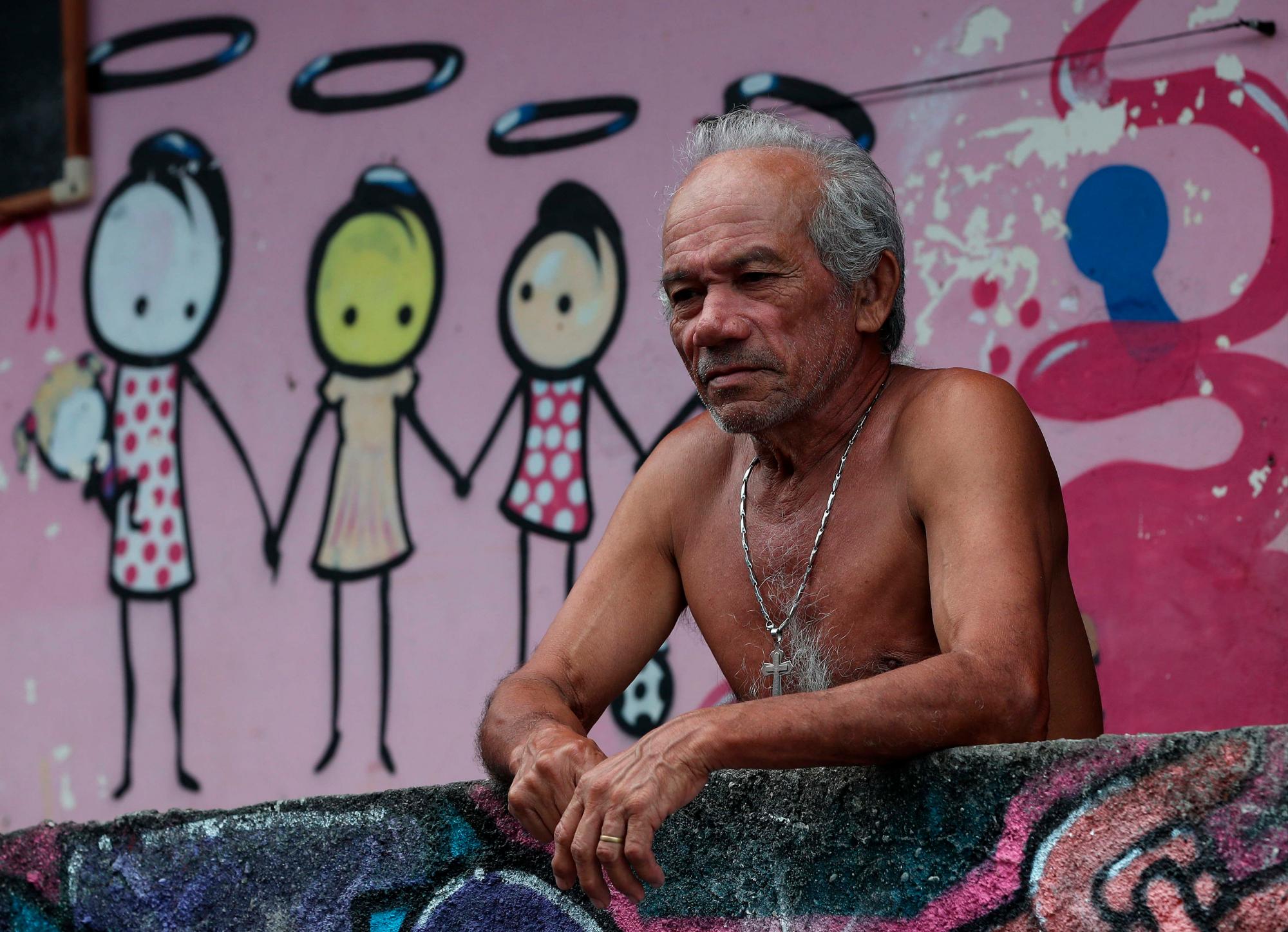 RÍO DE JANEIRO (BRASIL), 21/03/2019.- Un hombre observa desde su casa en la comunidad Tavares Bastos, este jueves en Río de Janeiro (Brasil). Lejos de la imagen de violencia e inseguridad de las favelas, en la zona sur de Río de Janeiro se encuentra la favela Tavares Bastos, una comunidad pacífica, sin tráfico ni milicias, reflejo de los grandes contrastes de Brasil, con olor a jazz, a arte urbano, a feminismo y a vecindad. EFE / Marcelo Sayão