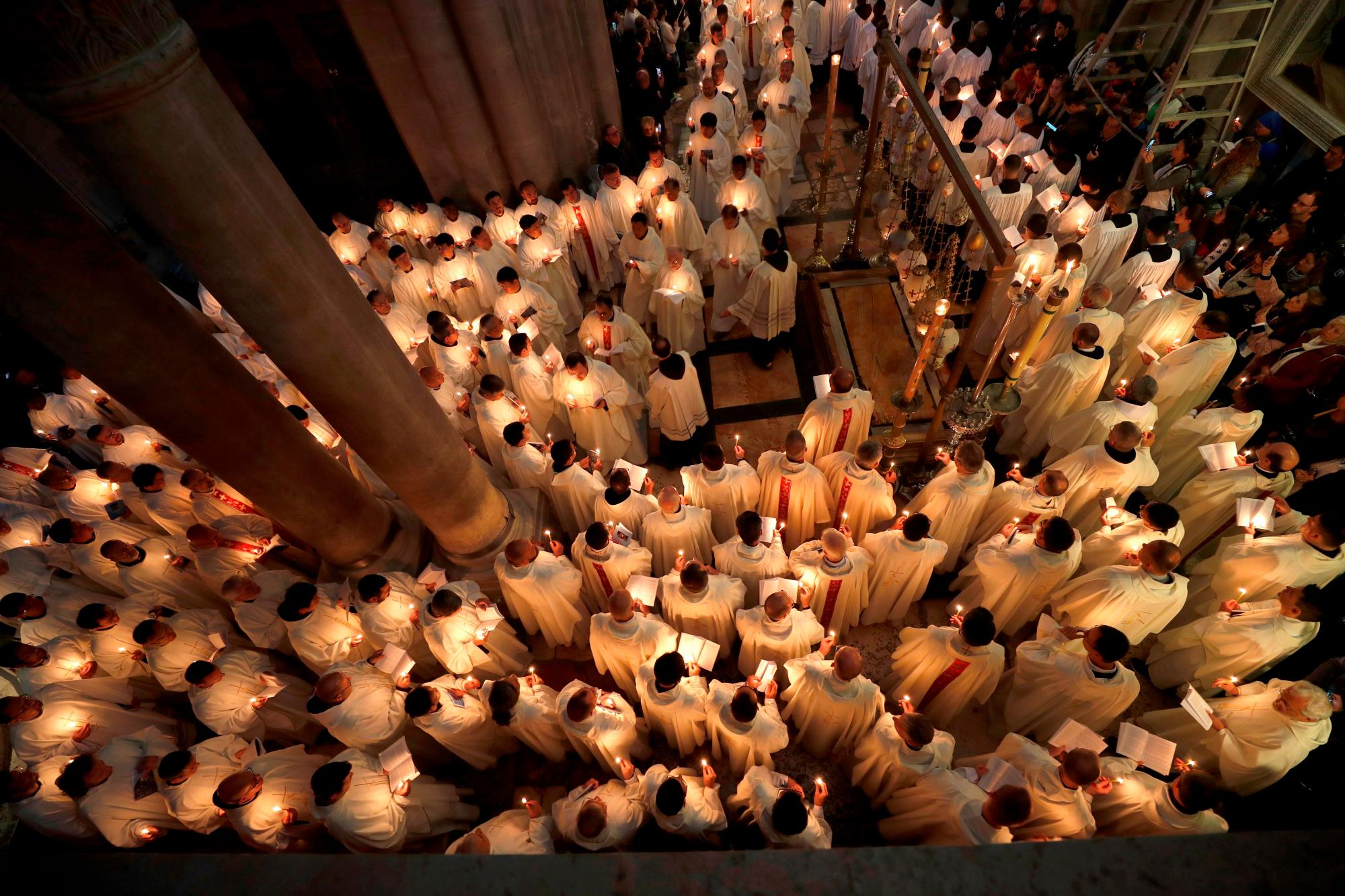Fieles cristianos en procesión durante la tradicional ceremonia del lavado de pies celebrada este Jueves Santo en la Iglesia del Santo Sepulcro de Jerusalén. 