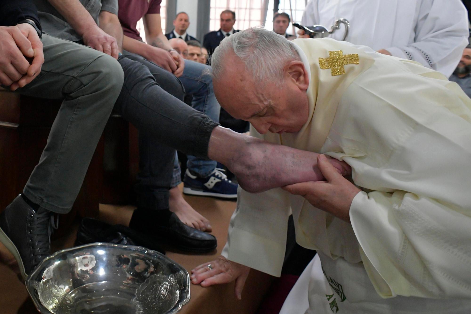 El papa Francisco (d) lava los pies a los reclusos durante su visita a la prisión de Velletri, donde celebró una misa por el Jueves Santo en Roma, Italia.