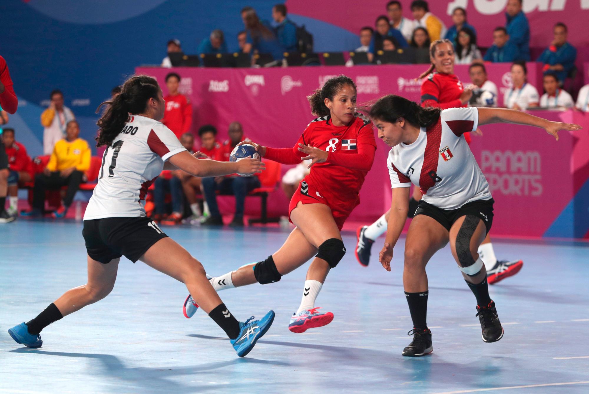 Nancy Peña (c) de Dominicana avanza frente a Camila Delgado (i) y Tifany Angulo (d) de Perú durante un partido de la ronda preliminar de balonmano femenino entre R.Dominicana y Perú en la primera jornada de los Juegos Panamericanos Lima 2019, en Lima (Perú). Los Juegos Panamericanos se disputarán del 26 de julio al 11 de agosto. 