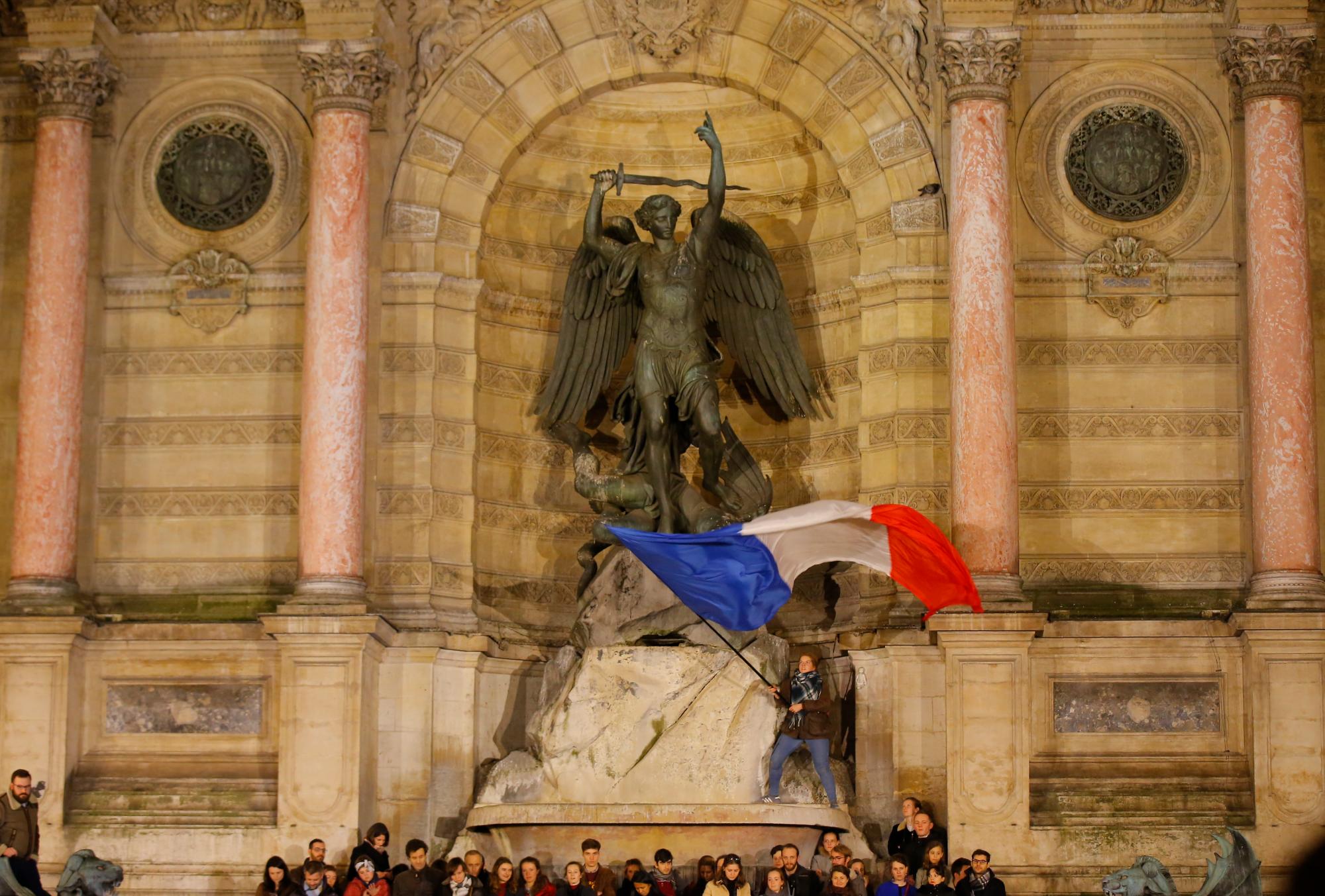 Una persona ondea una bandera francesa en una vigilia en París, Francia, el martes 16 de abril de 2019.