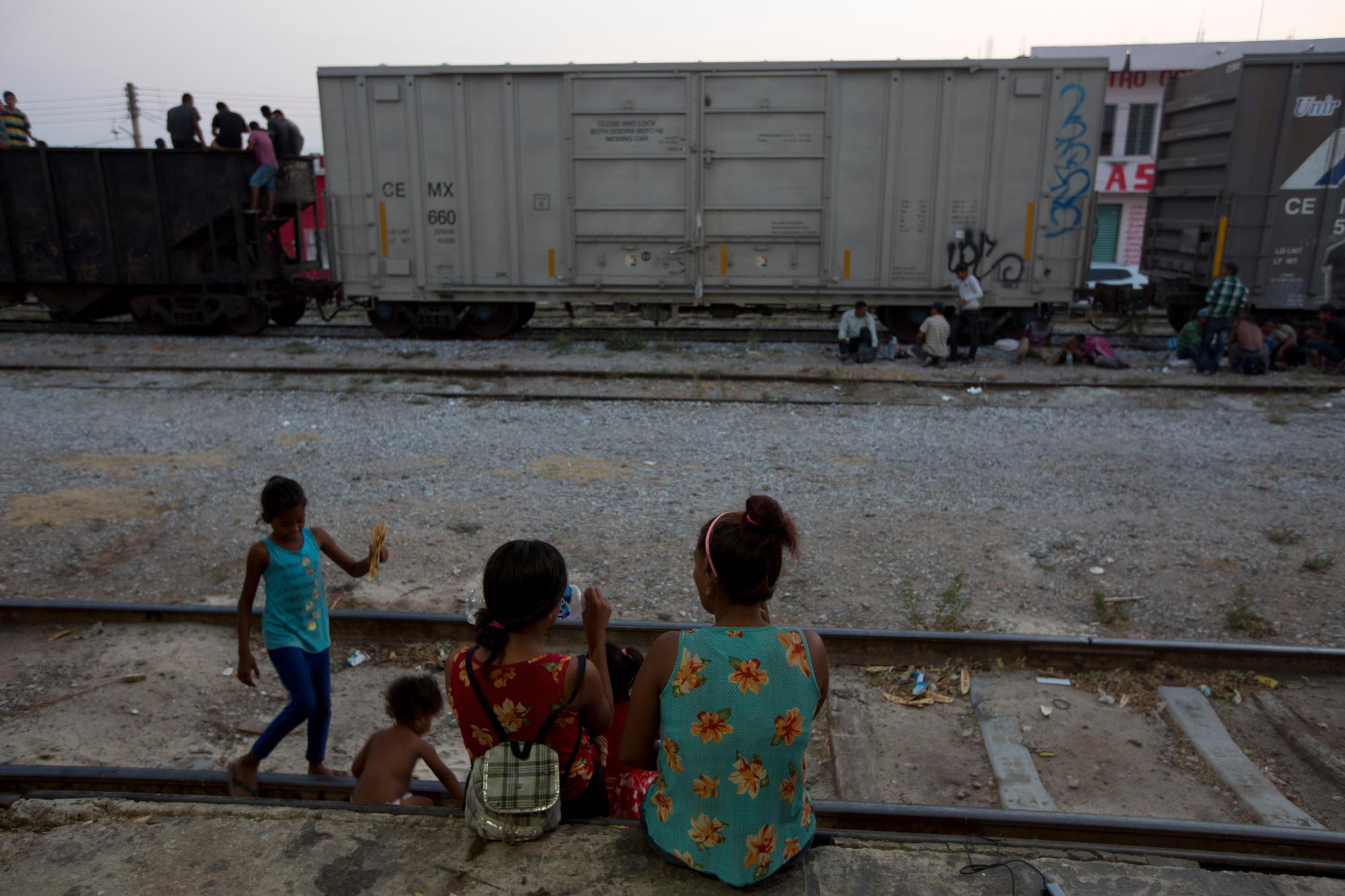 Una mujer migrante centroamericana con hijos descansan en la vía férrea durante su viaje hacia la frontera entre Estados Unidos y México en Arriaga, estado de Chiapas, México.