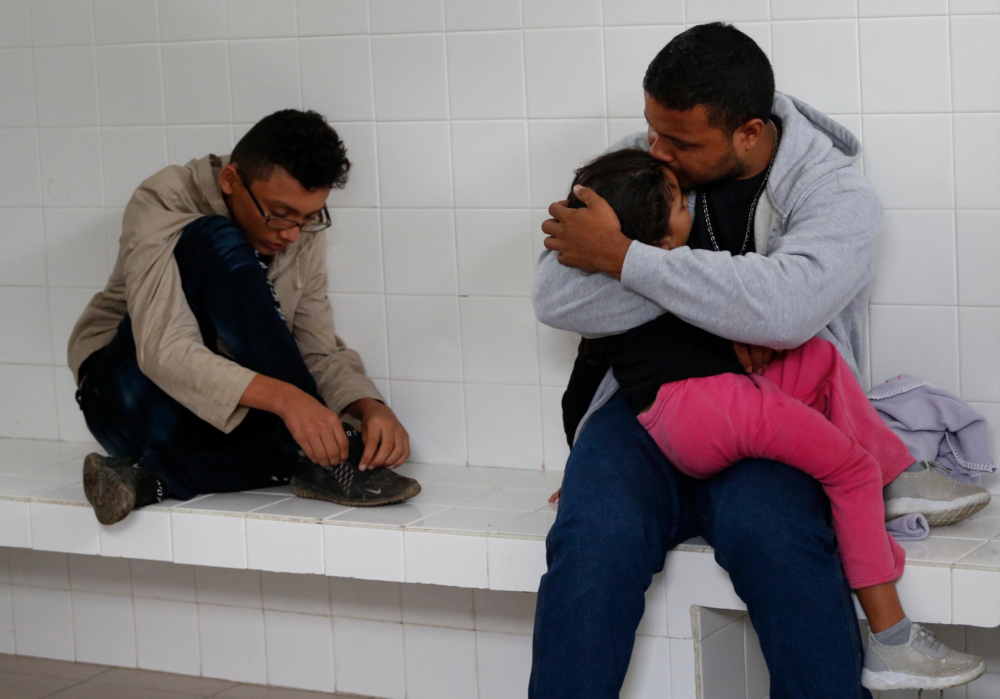El migrante hondureño Noe, de 31 años, besa a su hija Marlene, de 4 años, mientras esperan dentro de una celda de detención de inmigrantes después de ser retirado de un autobús que se dirige al norte de Comitan, estado de Chiapas, México, domingo 16 de junio de 2019.