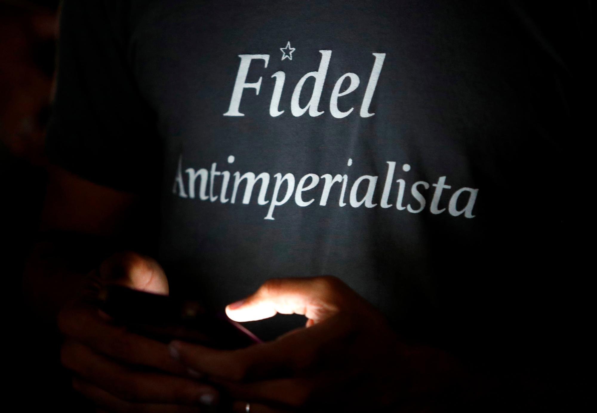 Un joven escribe en su celular este lunes durante el acto de homenaje por el tercer aniversario del fallecimiento del líder Fidel Castro.