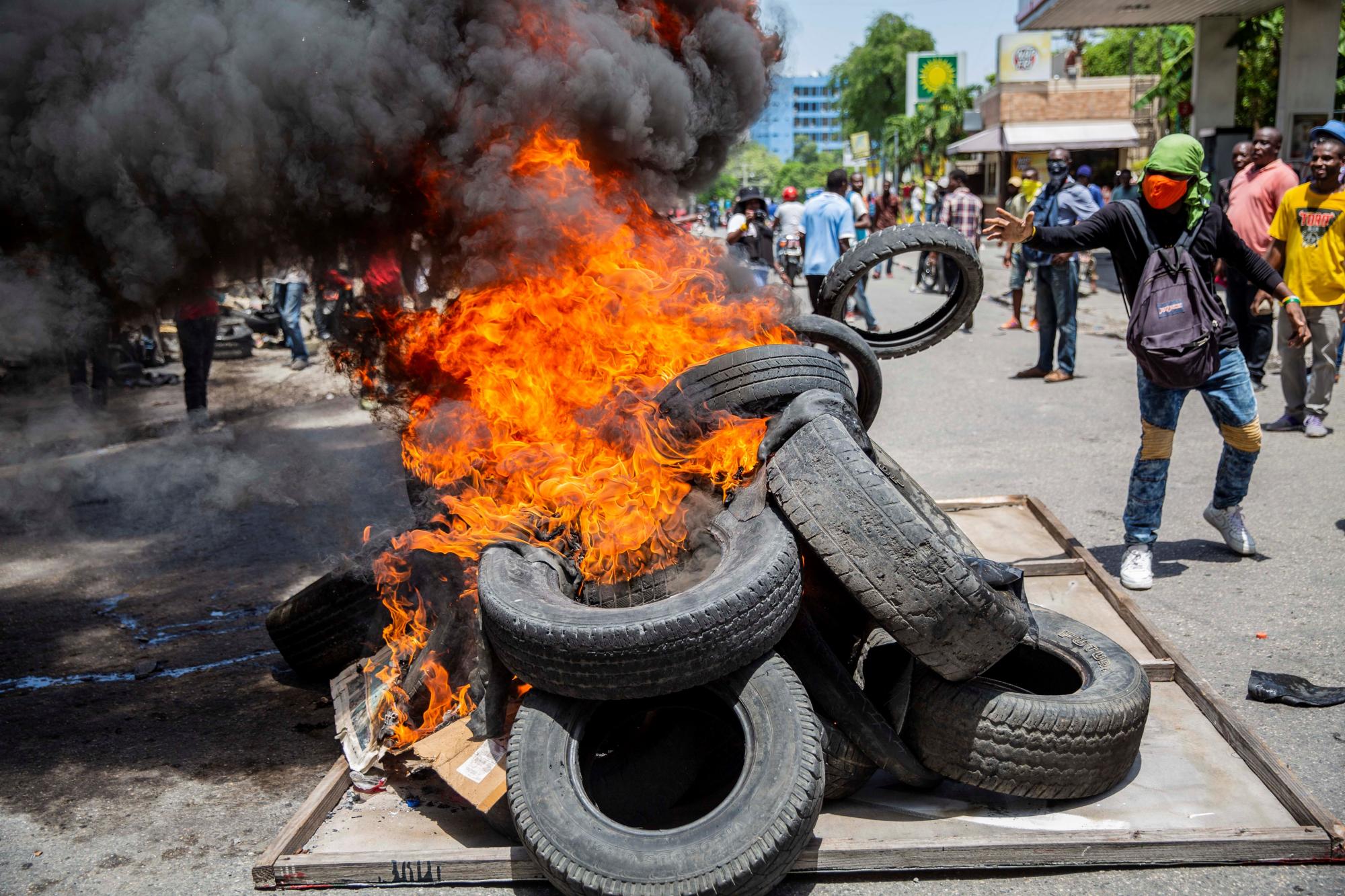Grupos de personas queman neumáticos durante una marcha contra la inseguridad y en repudio al asesinato del presidente del Colegio de Abogados del país, Me Monferrier Dorval, hoy, en las calles de Puerto Príncipe (Haití). (EFE/ Jeanty Emmanuel)
