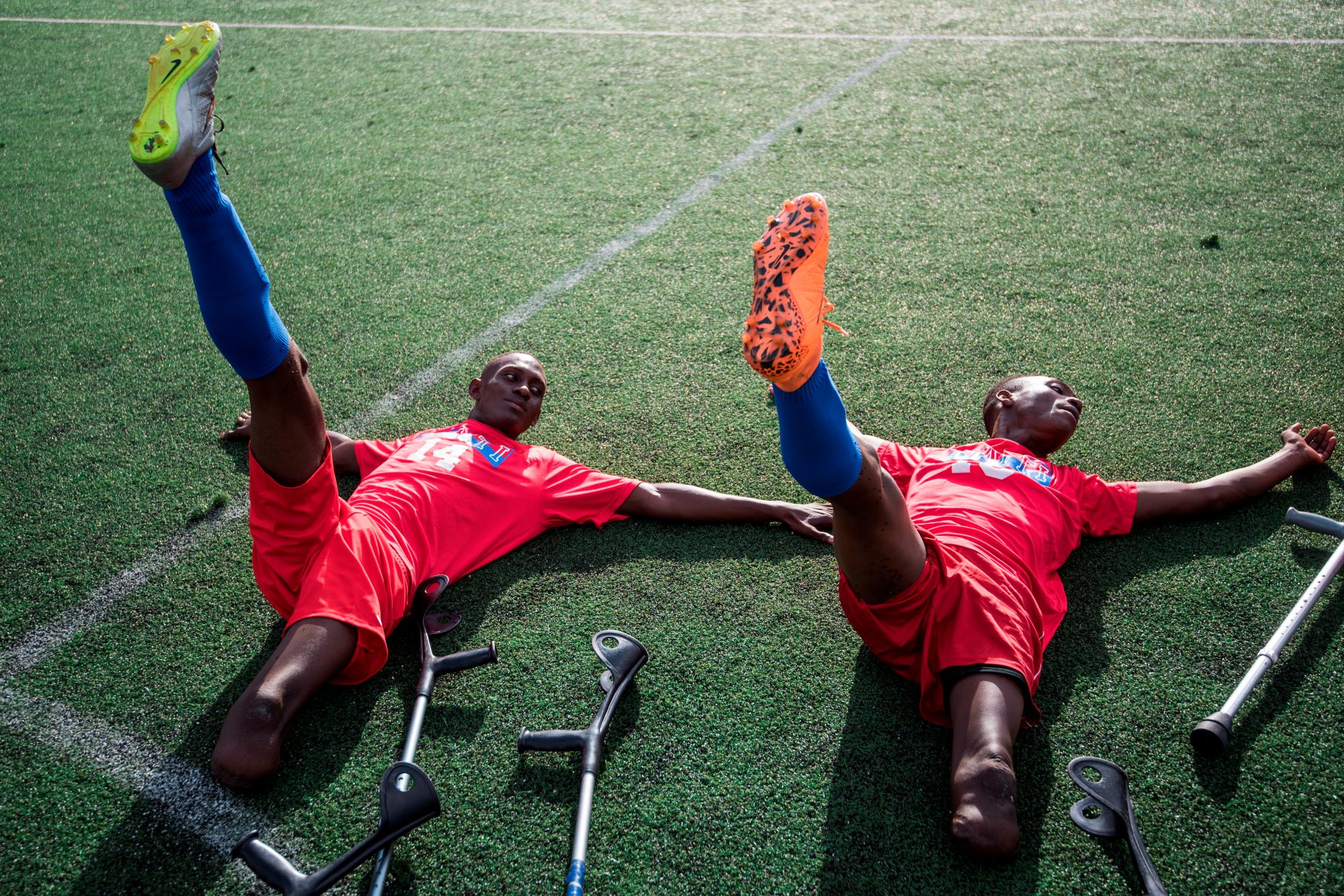 Dos jugadores de fútbol del equipo de Haití, víctimas del terremoto 2010 se estiran antes de dar inicio al partido “Dos muletas y un balón” con motivo del décimo aniversario del terremoto de Haití, en Santo Domingo (República Dominicana). 