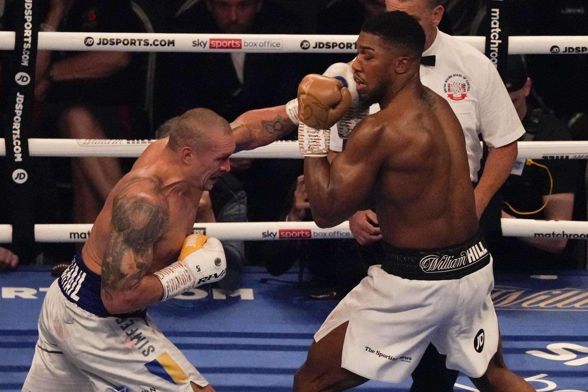 El ucraniano Oleksandr Usyk lanza un puñetazo al británico Anthony Joshua durante su combate por el cinturón de los pesados, el sábado 25 de septiembre de 2021, en Londres (AP/Frank Augstein)