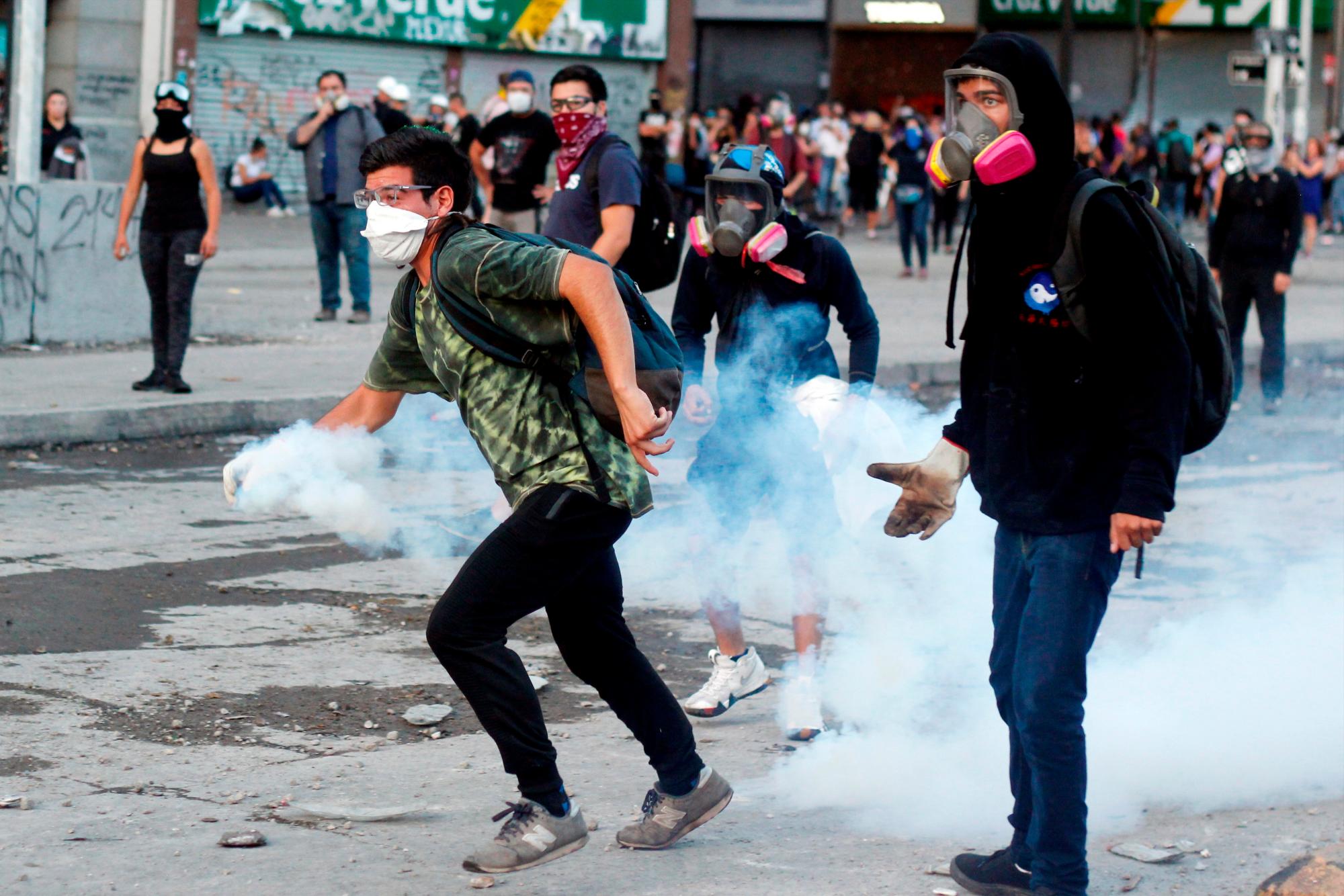 Manifestantes se enfrentan con la policía antidisturbios hoy miércoles 11 de marzo, durante las protestas en conmemoración a los dos años de gobierno de Sebastián Piñera, en Santiago de Chile (Chile).