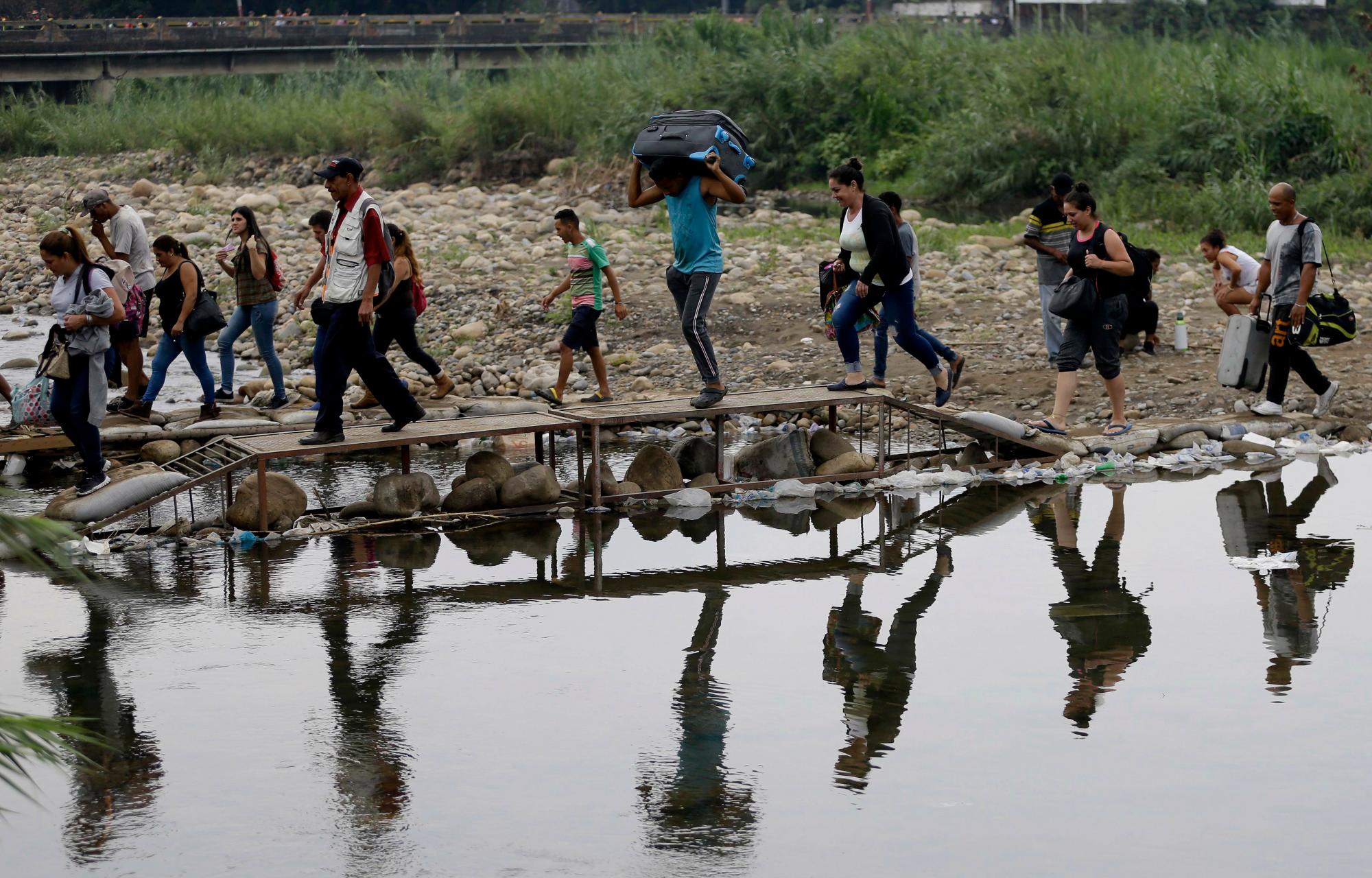 Los venezolanos cruzan ilegalmente a Colombia cerca del Puente Internacional Simón Bolívar, parcialmente cerrado por las autoridades venezolanas que sólo están permitiendo que estudiantes, ancianos y enfermos crucen, vistos desde La Parada cerca de Cúcuta, Colombia.