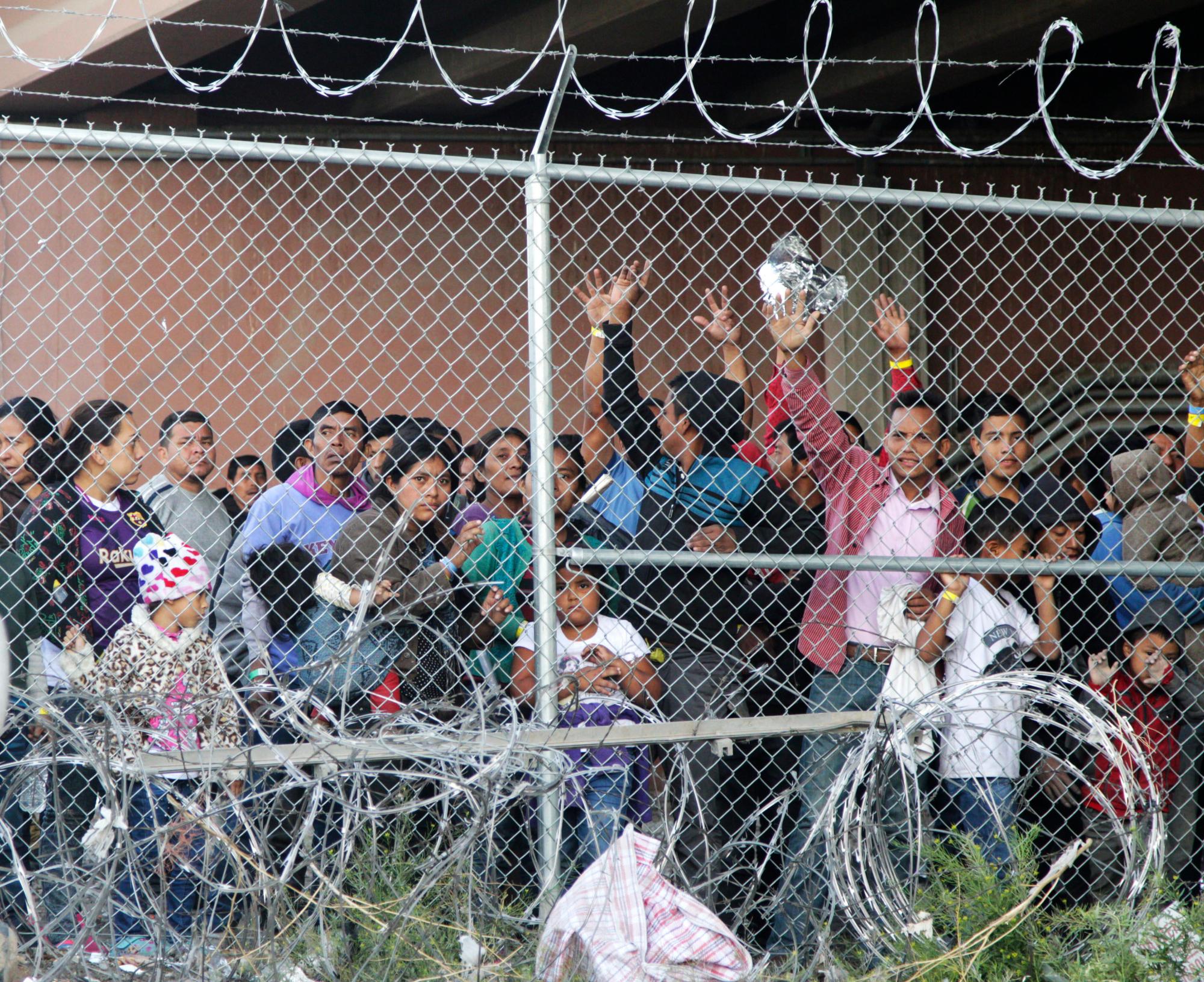  Los migrantes centroamericanos esperan comida en un albergue construido por la Oficina de Aduanas y Protección Fronteriza de los Estados Unidos para procesar un aumento de familias migrantes y menores no acompañados en El Paso, Texas.