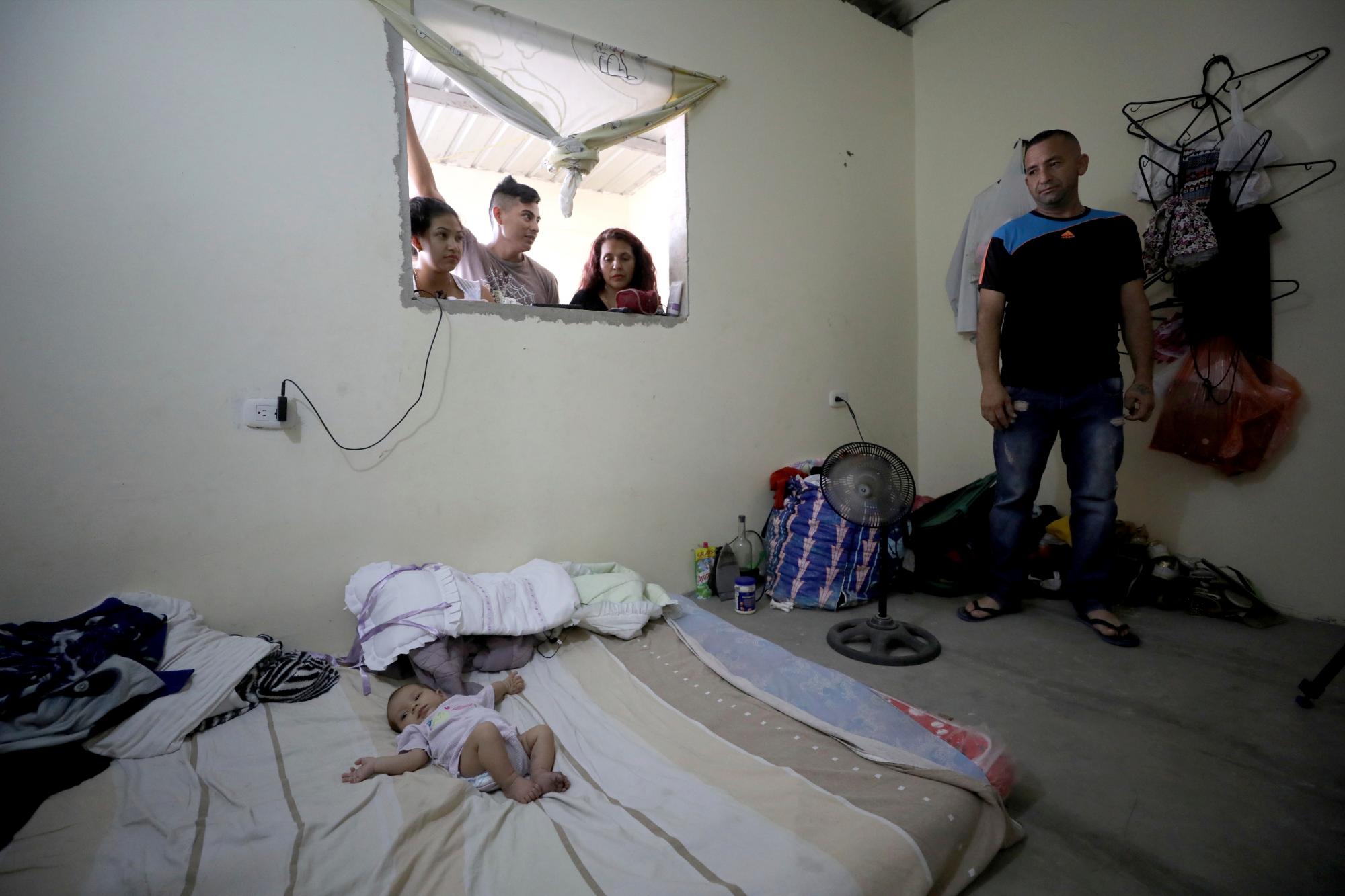 El inmigrante venezolano José Antonio Pulido, de pie junto a su hija de dos meses Zuleidys Antonella Primera, en su casa de Cúcuta, Colombia, el jueves 2 de mayo de 2019. 