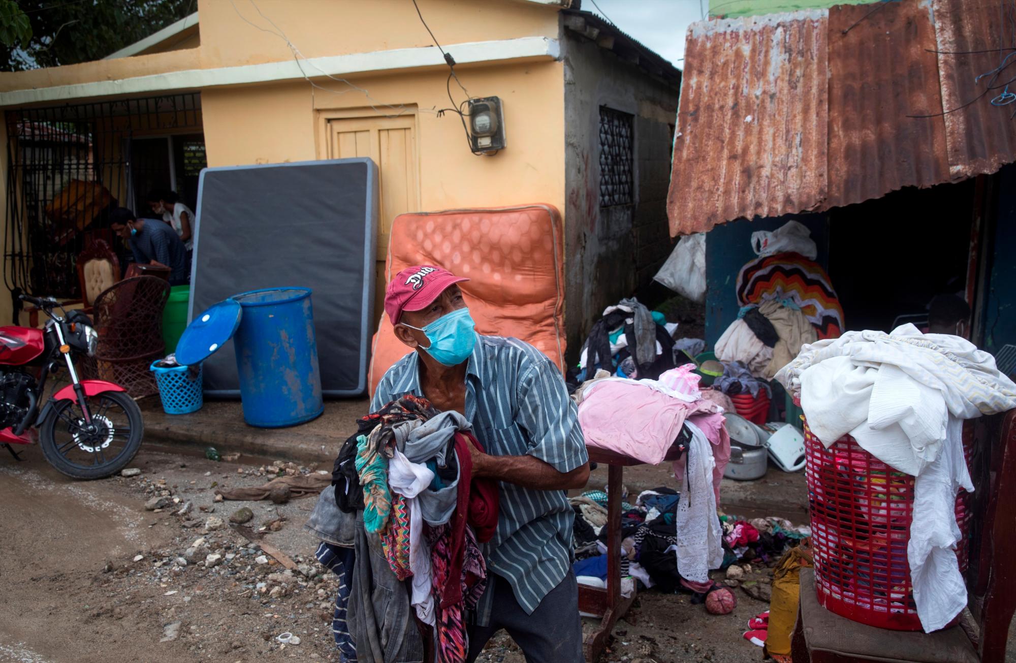 Un hombre lanza ropa al camión de basura, en una zona afectada por el paso del huracán Isaías, este viernes en Hato Mayor (República Dominicana). 