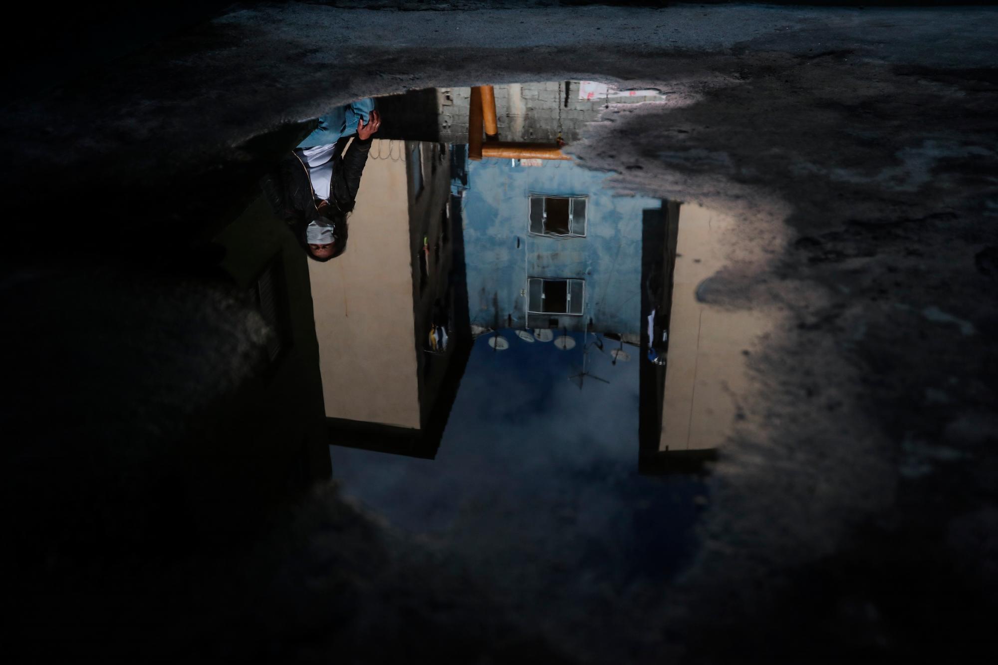 BRA300. SÃO PAULO (BRASIL), 27/08/2020.- Vista del reflejo de Joseane Santos en un charco el 24 de agosto de 2020 en Sao Paulo (Brasil). 