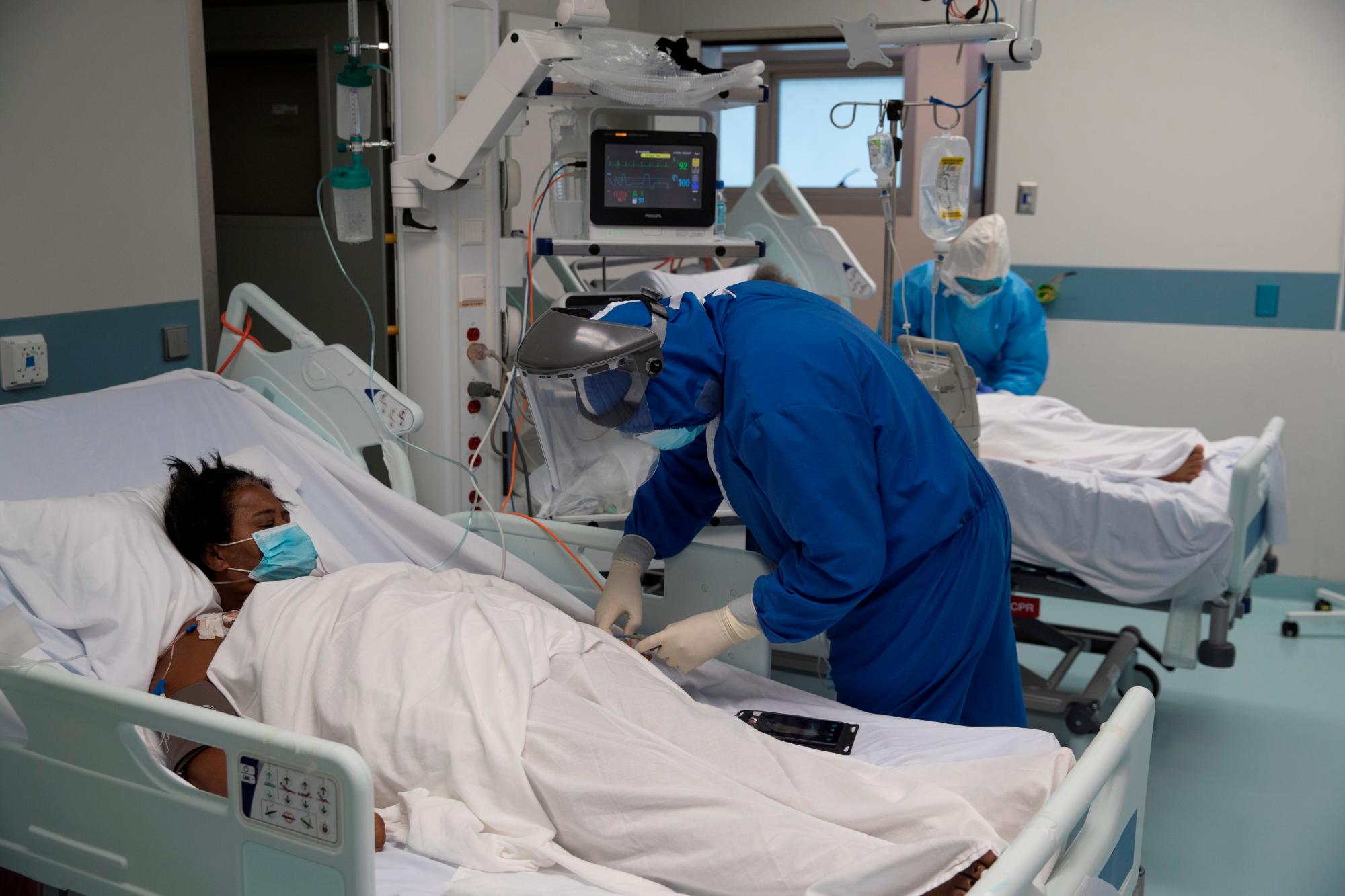 El personal médico atiende a dos mujeres en el área de recuperación de la Unidad COVID-19 del Centro de Oftalmología y Trasplante Cardio-Neuro (Cecanot) en Santo Domingo, República Dominicana, el 15 de mayo de 2020. Durante todo el día, 63 médicos, 120 enfermeras y 35 Los empleados de servicios generales atienden a unos 40 pacientes en el centro de salud. EFE / Orlando Barria