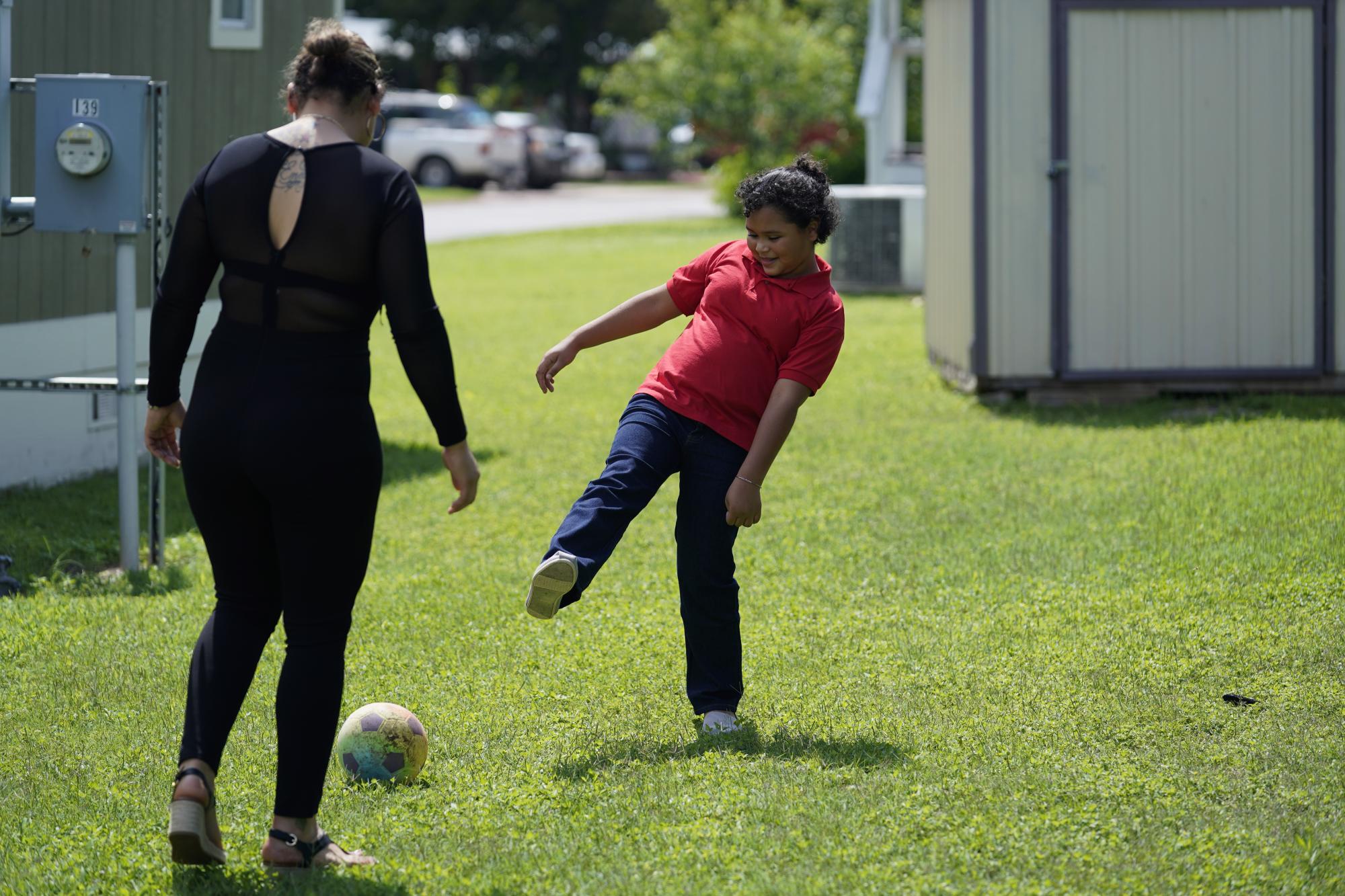 Glenda Valdez (de espaldas) y su hija Emely juegan con un balón en su casa de Austin, Texas, el 6 de junio del 2021, tras un emotivo reenecuentro después de estar separadas seis años.