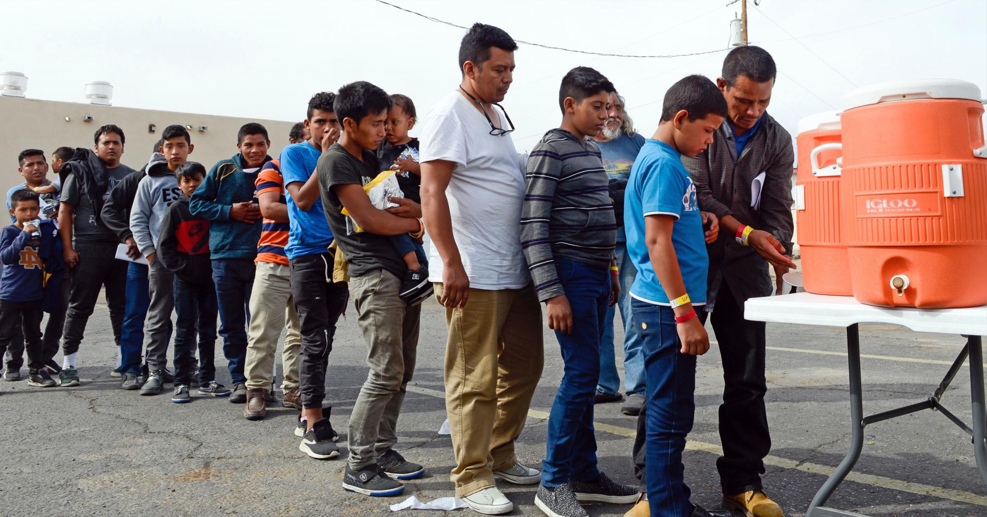  Los migrantes esperan en la cola para tomar liquidos después de ser dejados por la Patrulla Fronteriza en la Misión de Rescate del Evangelio en Las Cruces, Nuevo México.