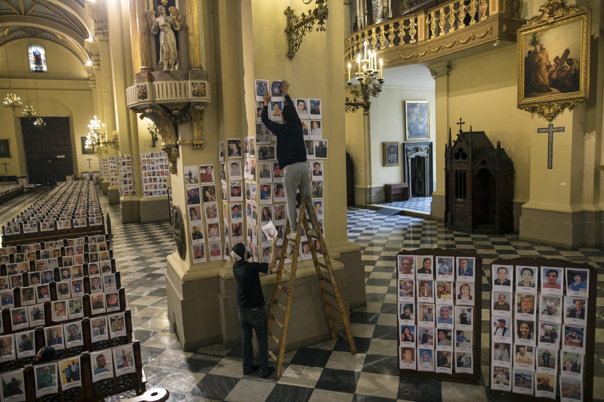 ARCHIVO - En esta fotografía de archivo del 13 de junio de 2020, los trabajadores colocan más de 4.000 retratos de personas que murieron de COVID-19 dentro de la Catedral de Lima, Perú. La pandemia de coronavirus ha modificado las prácticas del culto católico en América Latina: iglesias cerradas, misas virtuales y cancelación de peregrinaciones masivas. 