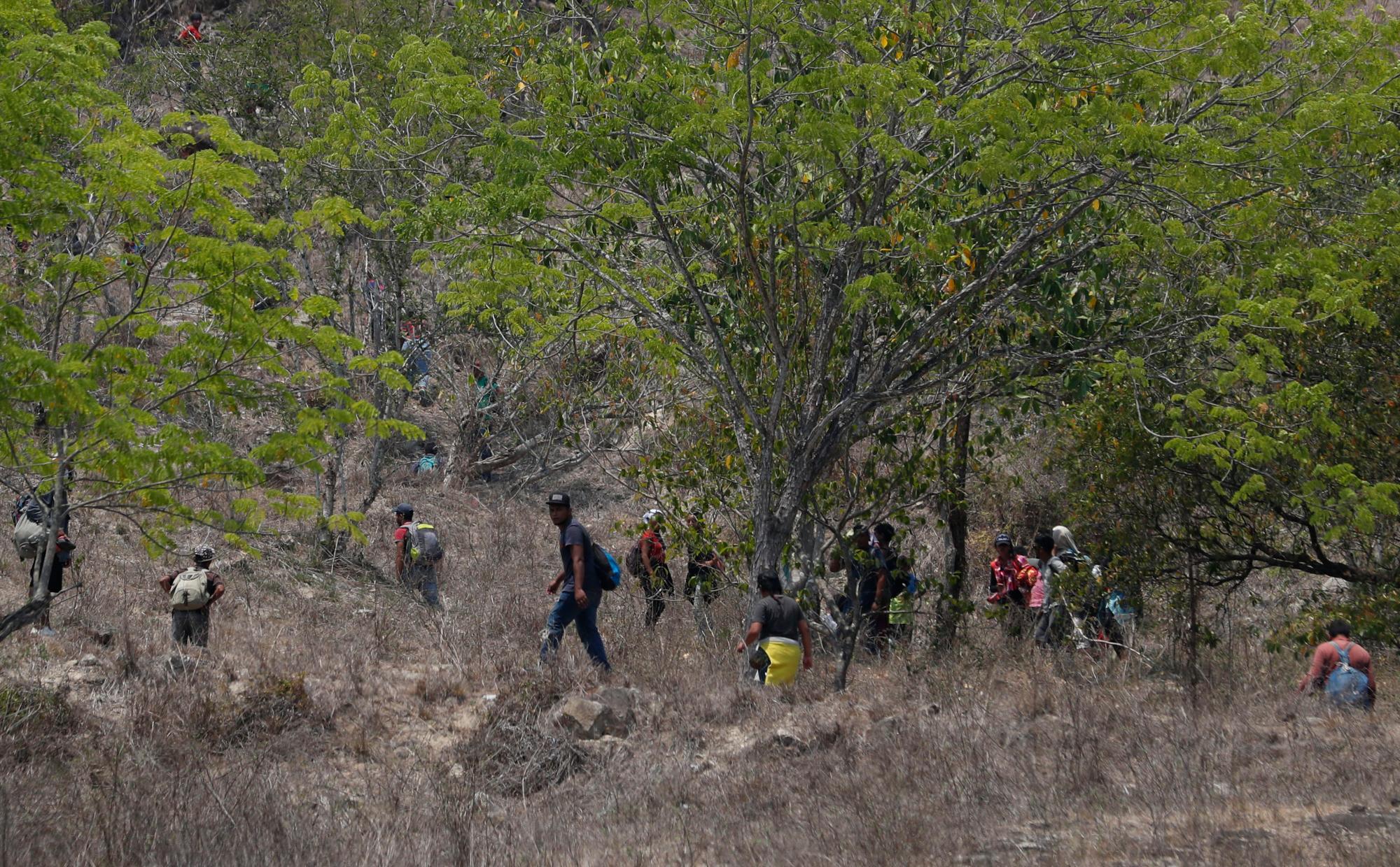 Los migrantes centroamericanos intentan evadir a los agentes de inmigración mexicanos en la carretera a Pijijiapan, México. La policía mexicana y los agentes de inmigración detuvieron a cientos de migrantes centroamericanos en el mayor ataque individual de una caravana migrante desde que los grupos empezaron a moverse por México el año pasado.