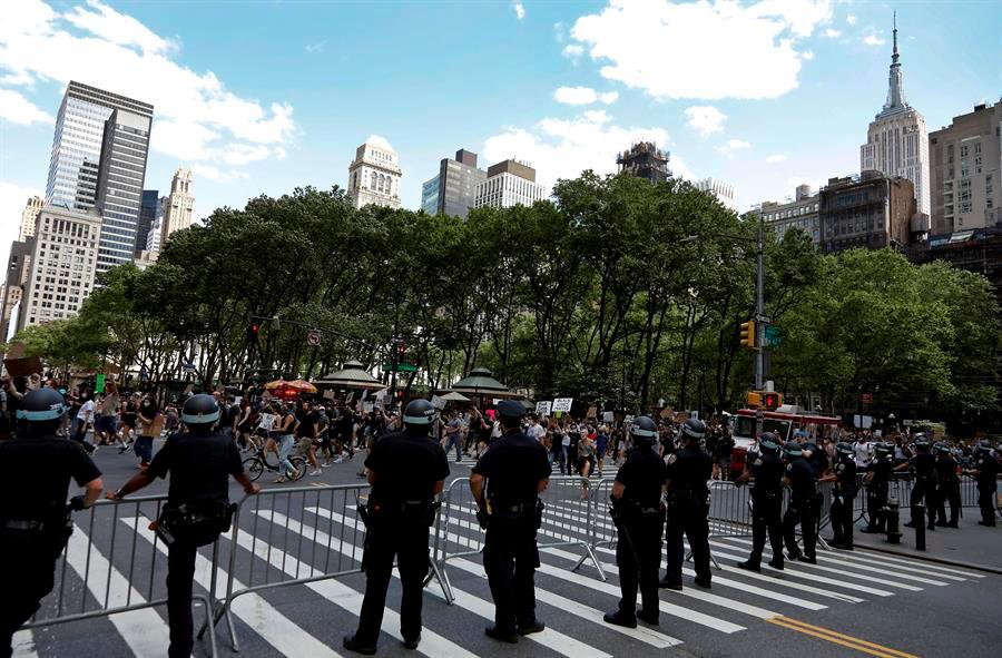 Miembros del Departamento de Policía de la ciudad de Nueva York observan a los manifestantes que marchan frente a Bryant Park en Nueva York, EE. UU., el 7 de junio de 2020, en medio de las protestas por la muerte de George Floyd.