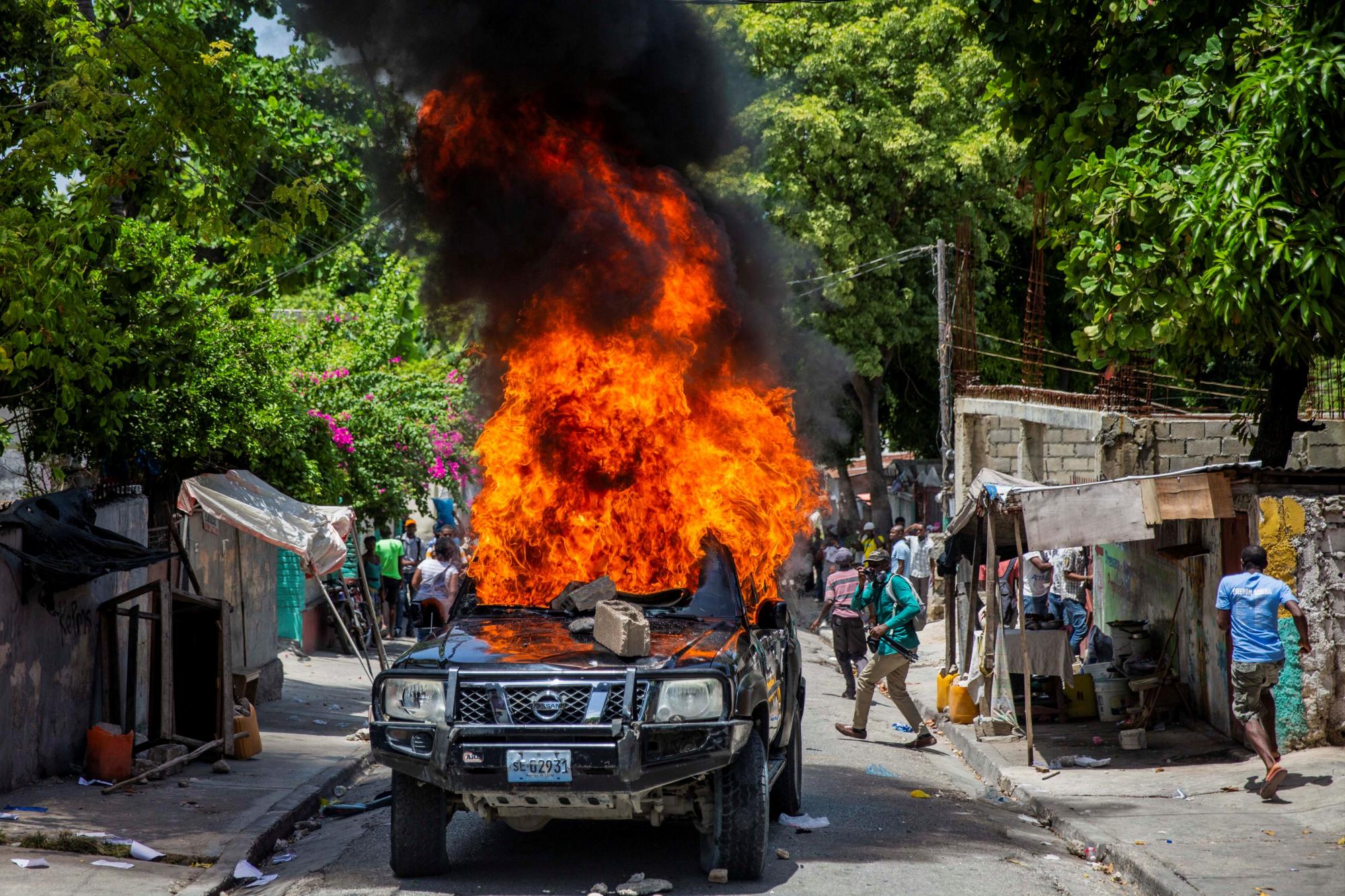 Vista de un automóvil quemado durante una marcha contra la inseguridad y en repudio al asesinato del presidente del Colegio de Abogados del país, Me Monferrier Dorval, hoy, en las calles de Puerto Príncipe (Haití). (EFE/ Jeanty Emmanuel)