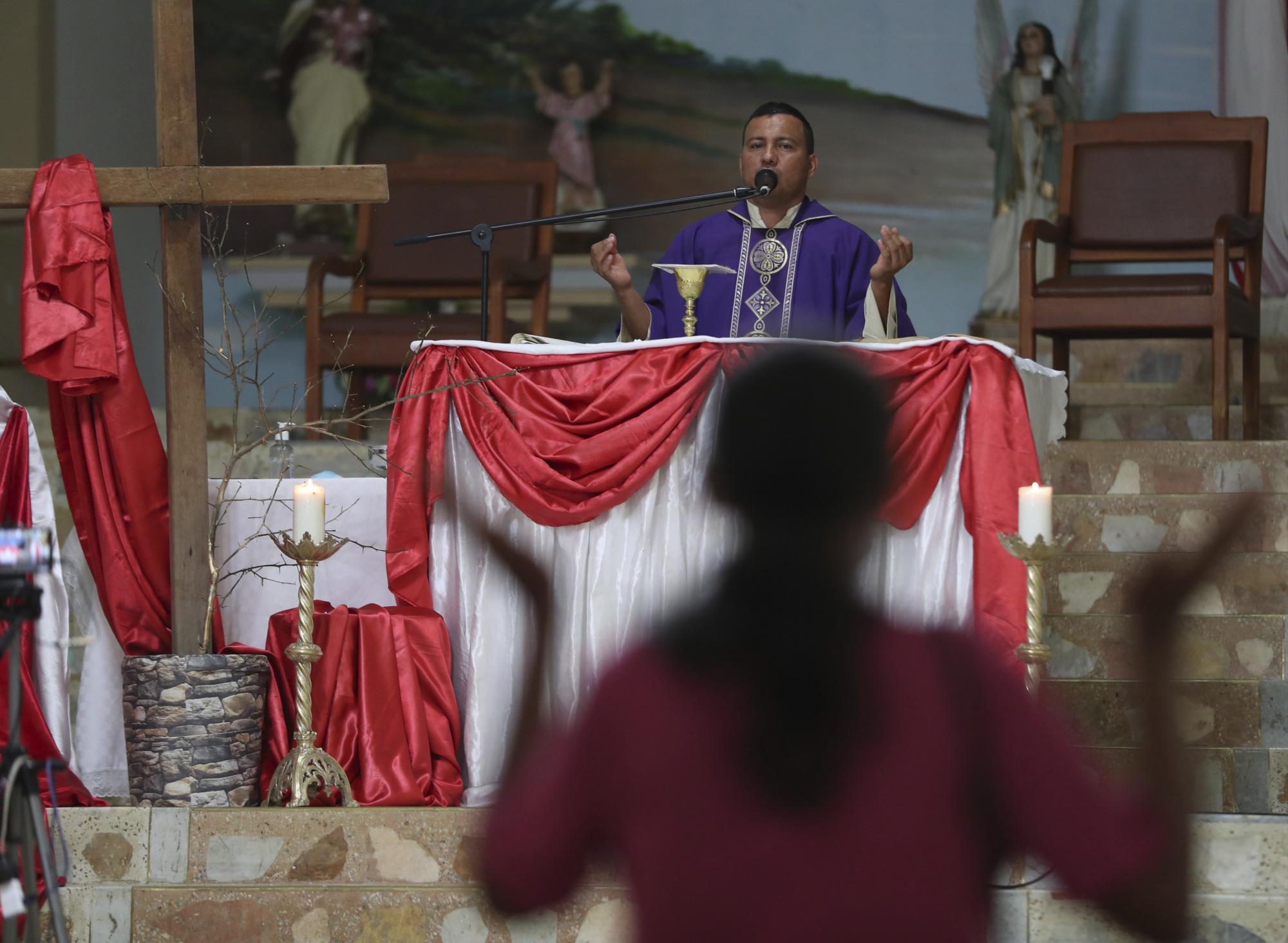 El padre Camilo Monrroy celebra misa en Campohermoso, Colombia, el jueves 18 de marzo de 2021, en medio de la nueva pandemia de coronavirus. El padre Monrroy dice que la oración constante de los ciudadanos del pueblo, especialmente a San Roque, patrón de la parroquia, los enfermos y las epidemias, ha convertido a San Roque en el patrón del pueblo. 