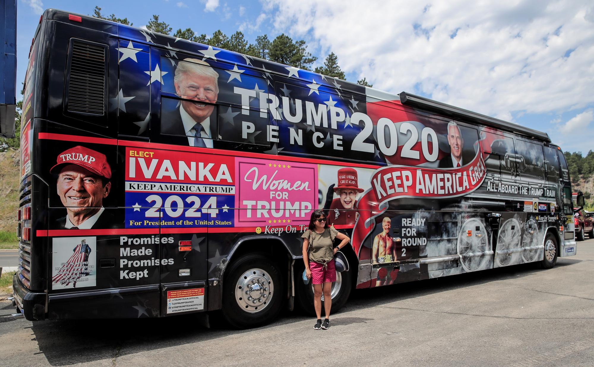 Una mujer posa frente a un autobús que forma parte del equipo de campaña del presidente Donald Trump en las horas previas a su visita al Monte Rushmore. (EFE/EPA/TANNEN MAURY)