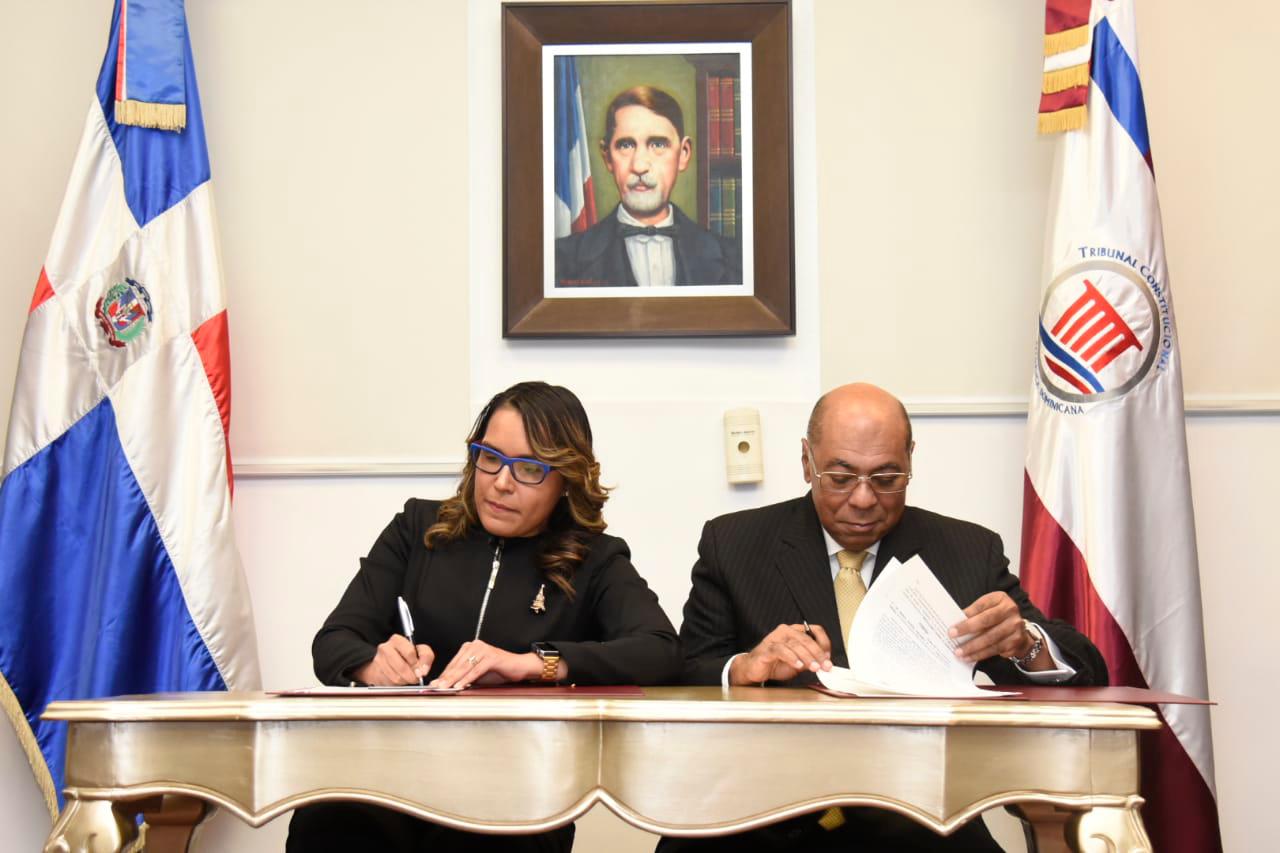 Francina Hungría y Milton Ray Guevara mientras firman el acuerdo.