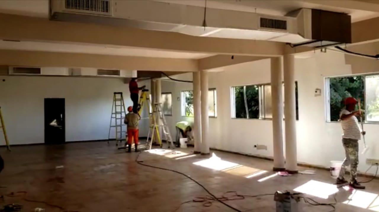 Varios hombres trabajan en el acondicionamiento del local que será utilizado como zona de aislamiento para pacientes con COVID-19, en San Francisco de Macorís. 